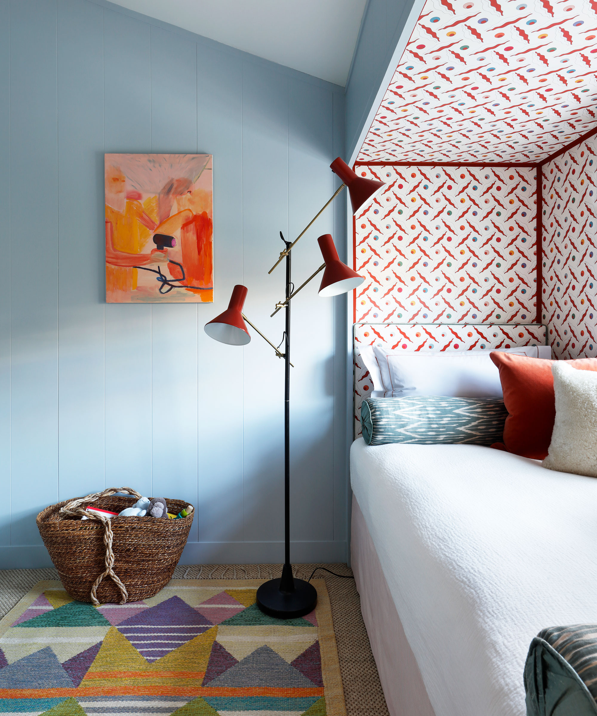 Petite chambre avec murs bleus et tapis à motifs