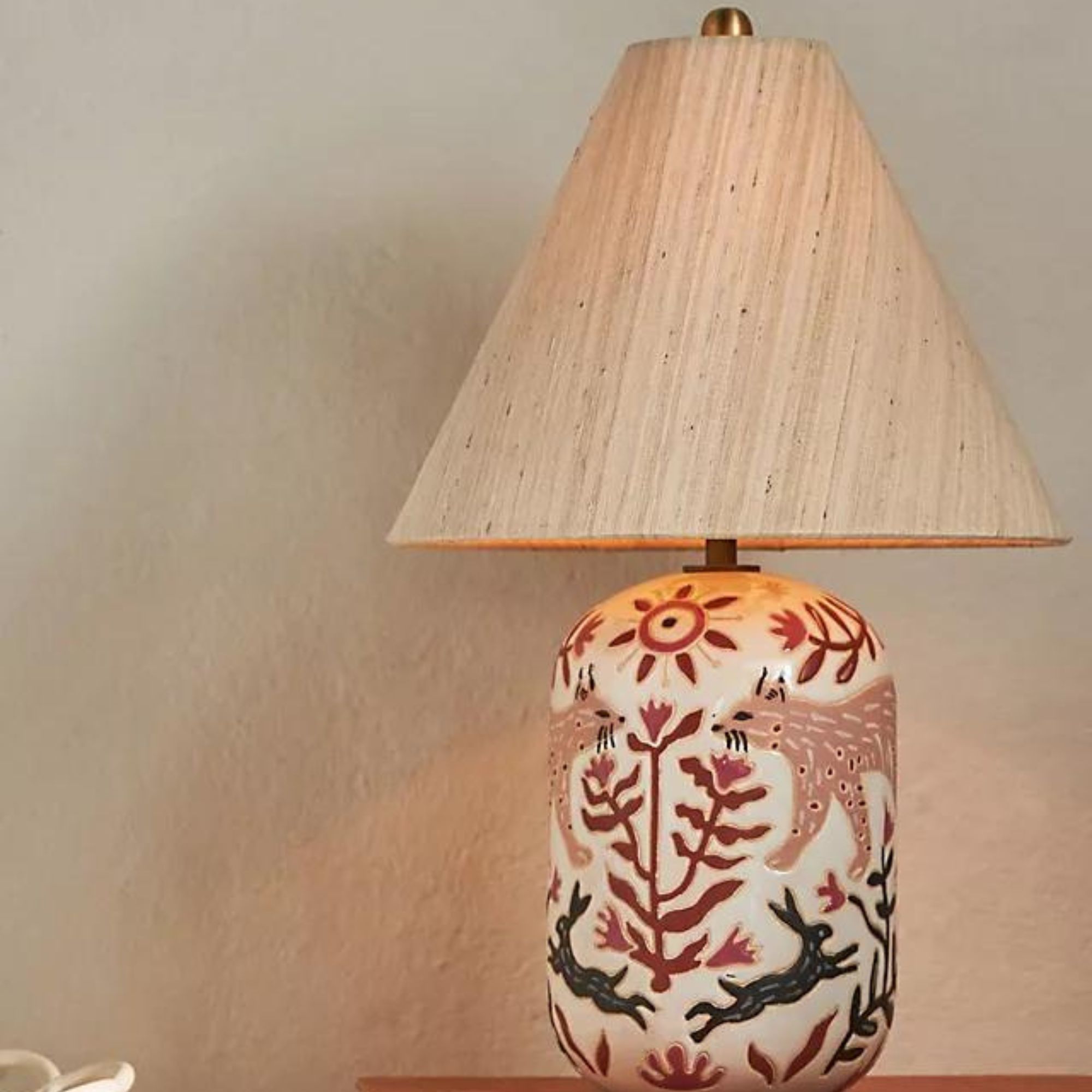 Un abat-jour beige sur une lampe de table peinte
