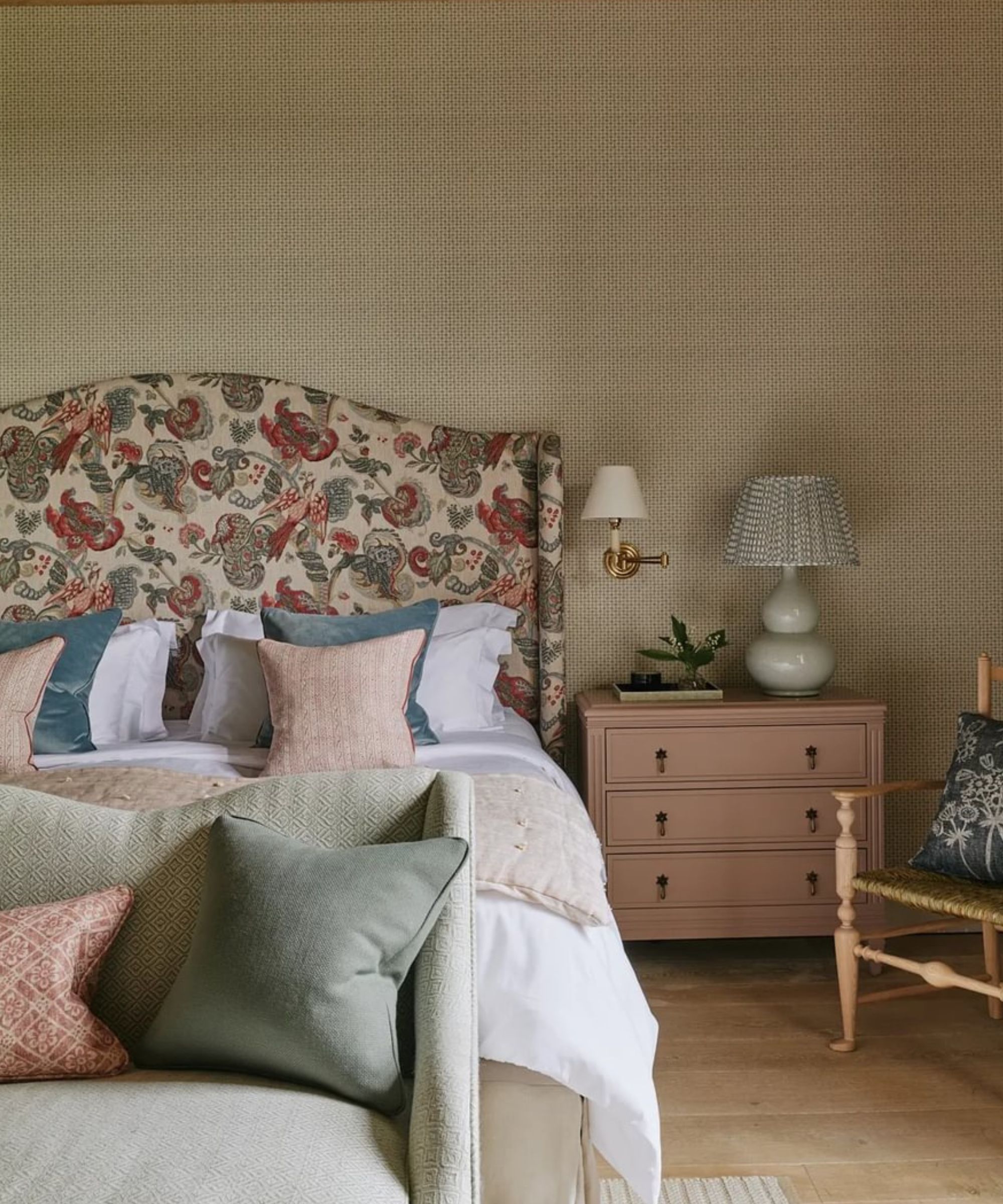 Chambre avec tête de lit rembourrée, lampe de table, applique et canapé
