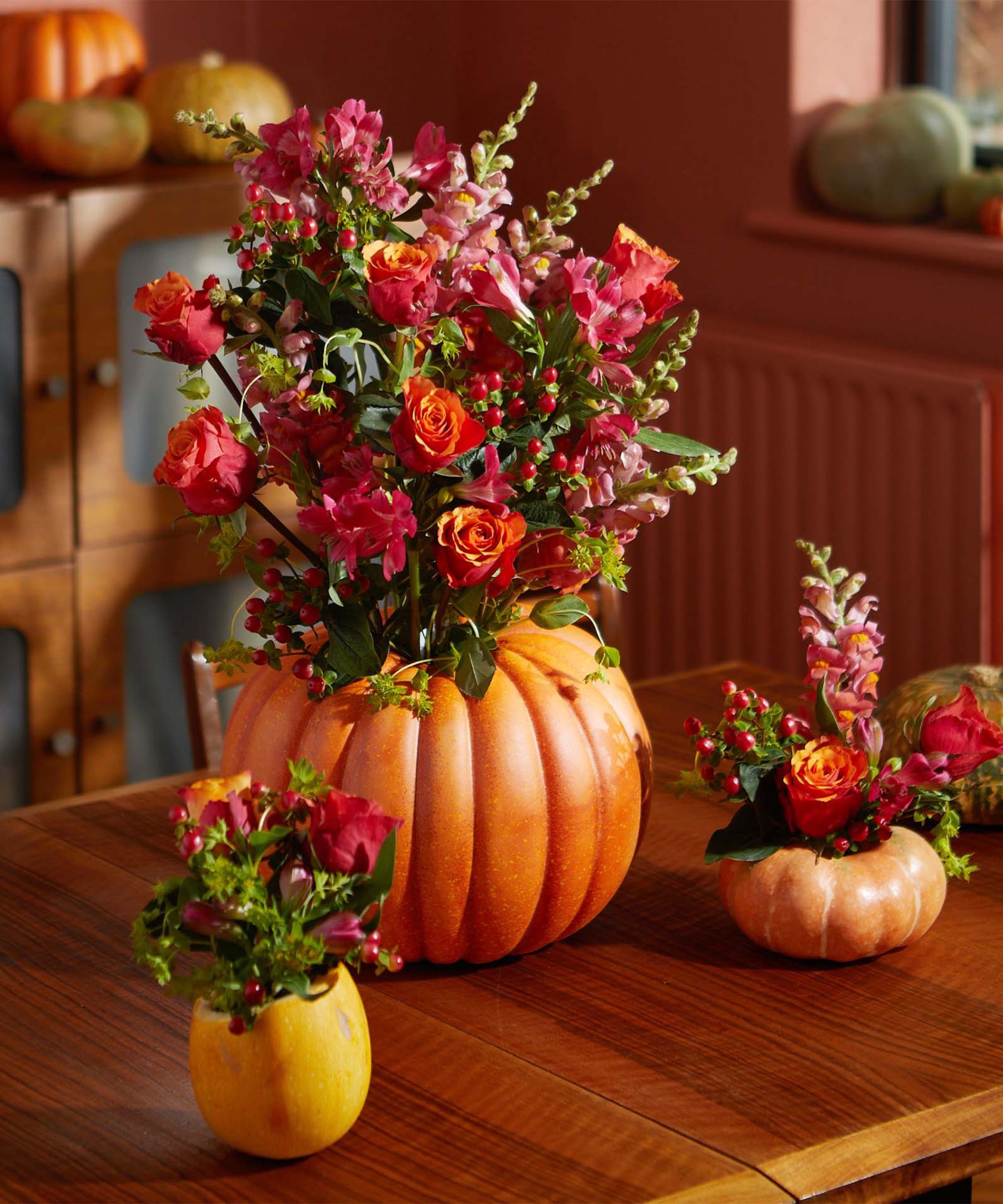 citrouilles sculptées dans des vases et remplies de fleurs fraîches