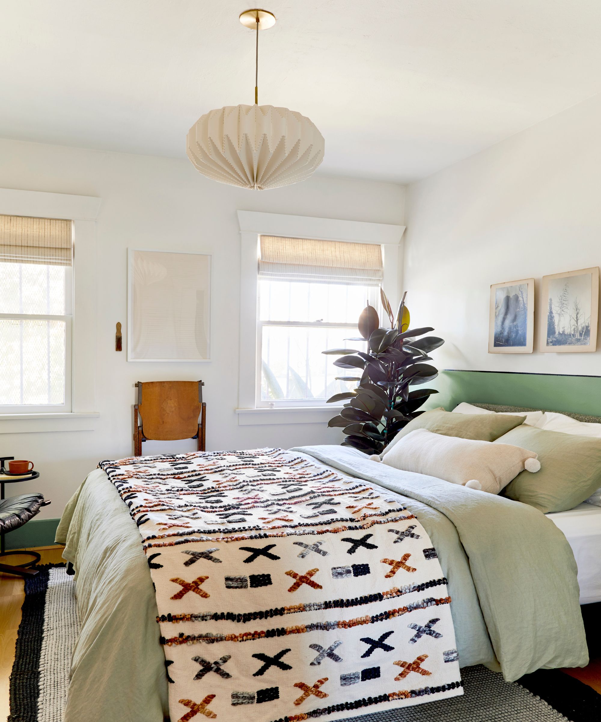 Petite chambre aux murs neutres, literie verte et jeté à motifs