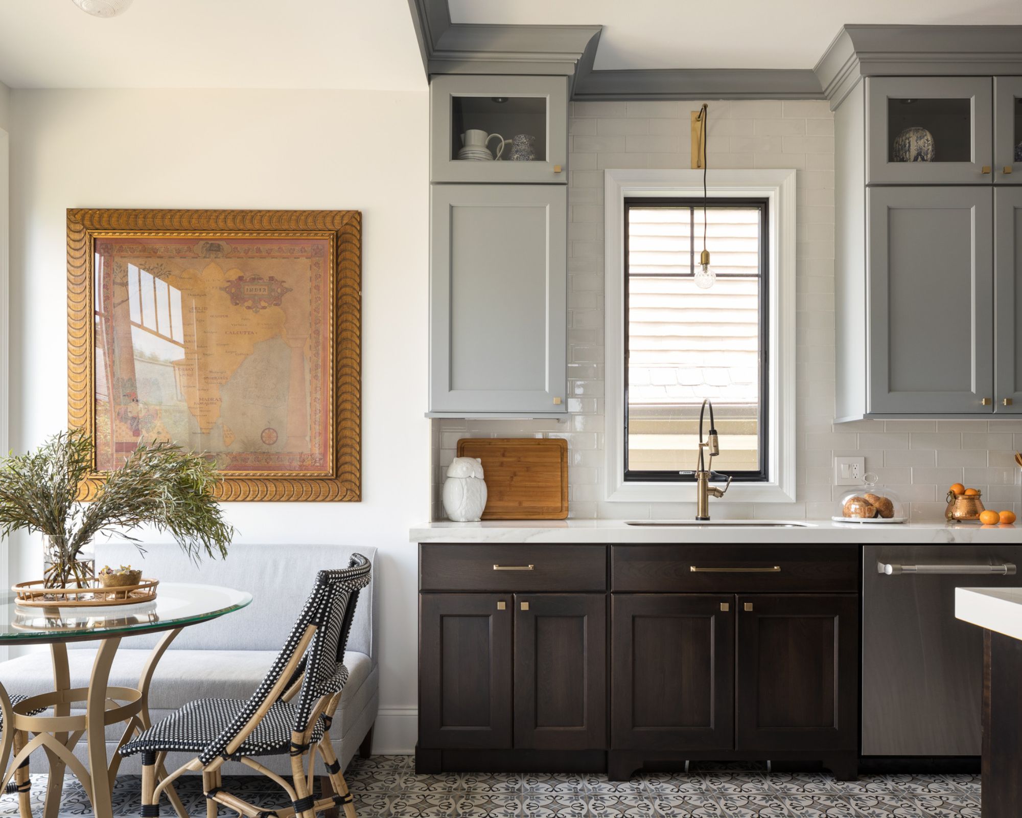 cuisine avec armoires inférieures noires, armoires supérieures grises, murs blancs et décoration moderne
