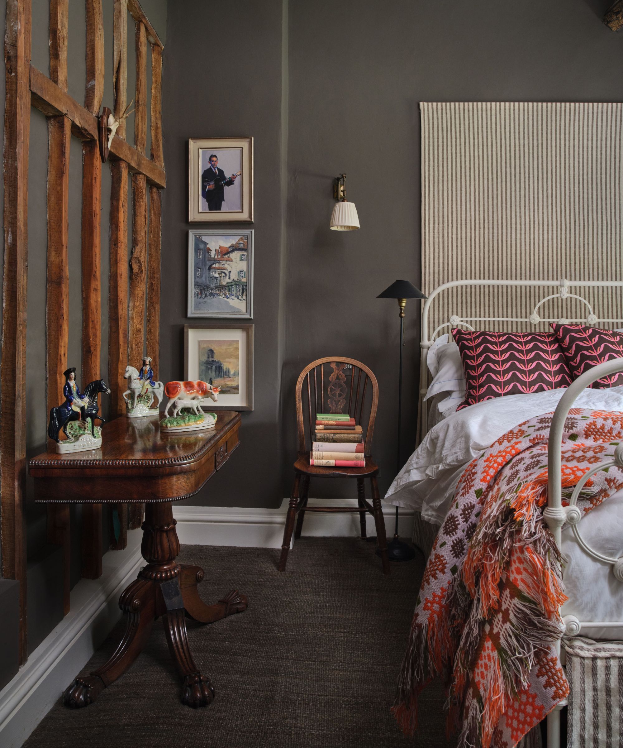 Chambre peinte gris foncé avec une table d'appoint en acajou et un lit moderne