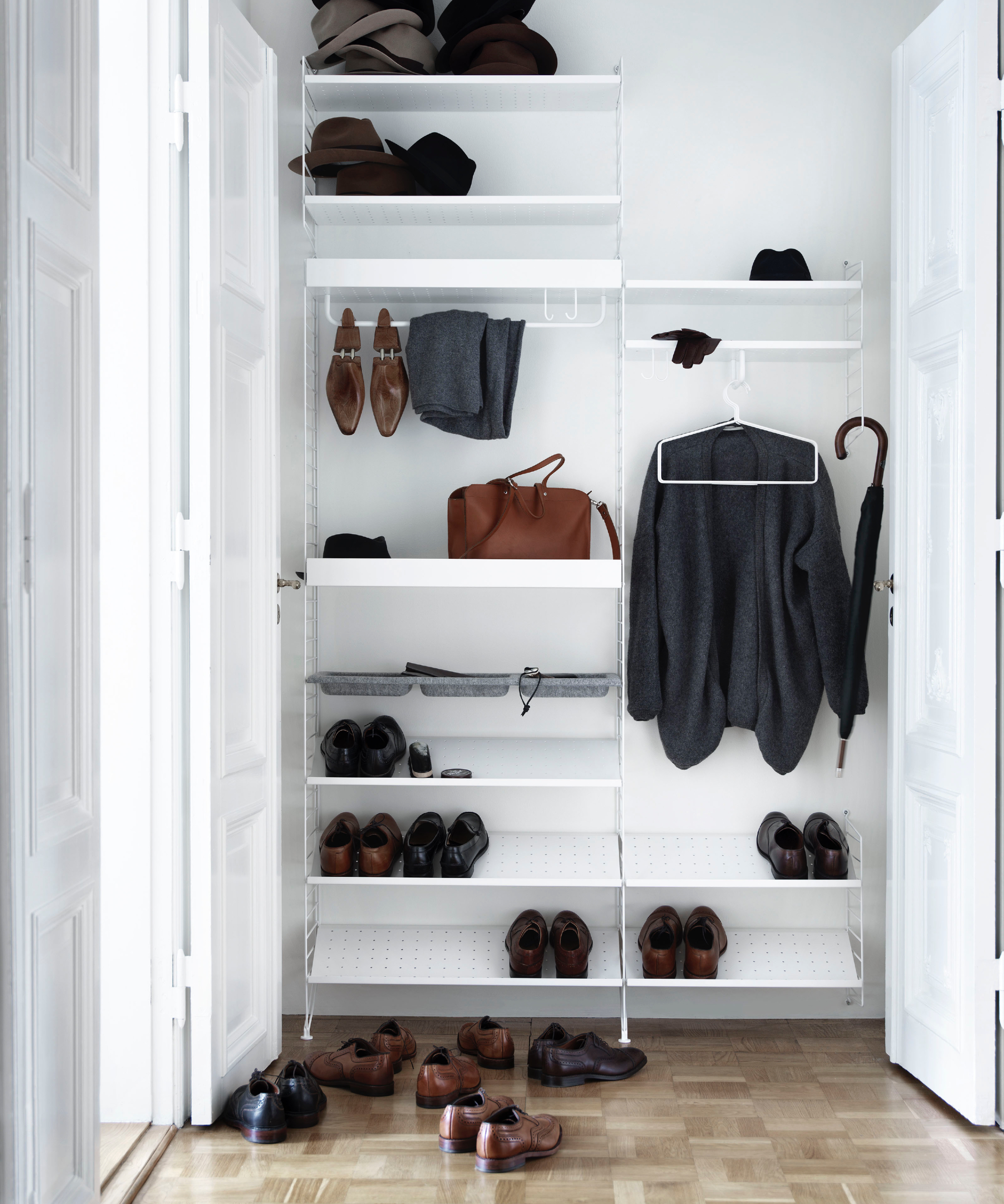String Metal String System en blanc avec panneaux muraux blancs, chaussures et vêtements suspendus, revêtement de sol en parquet