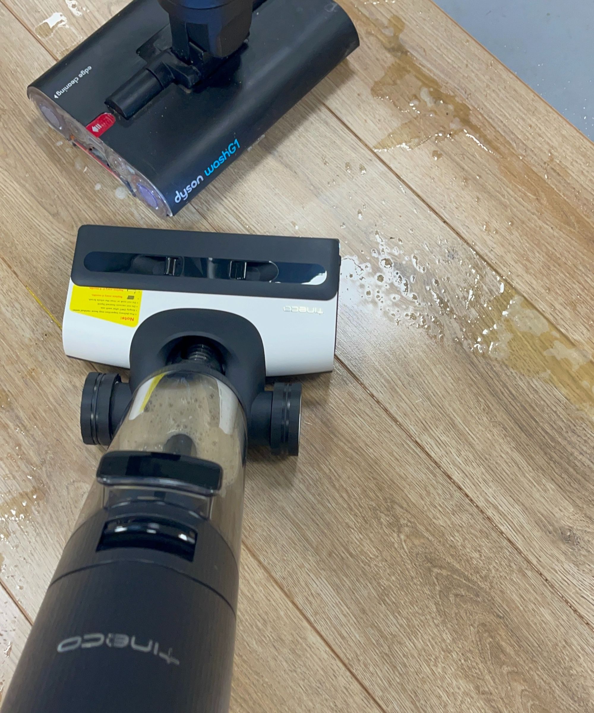 Tineco Floor One S7 Pro Cordlessles Wet Wet Apium et Dyson Washg1 sur le plancher en bois dans le futur centre d'essai