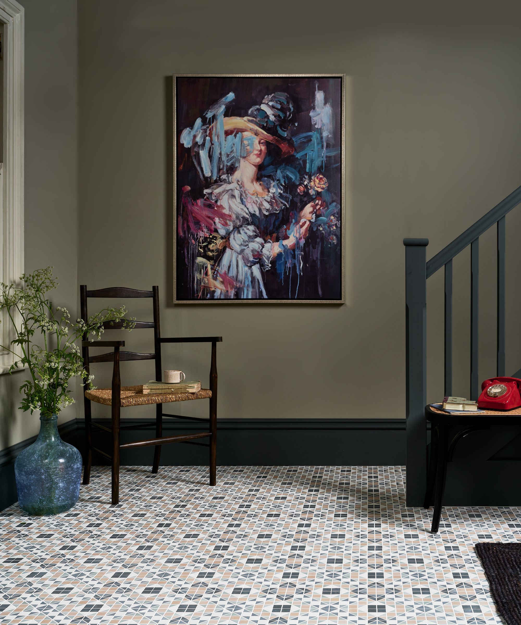 sol mosaïque avec mur vert et chaise noire et escalier