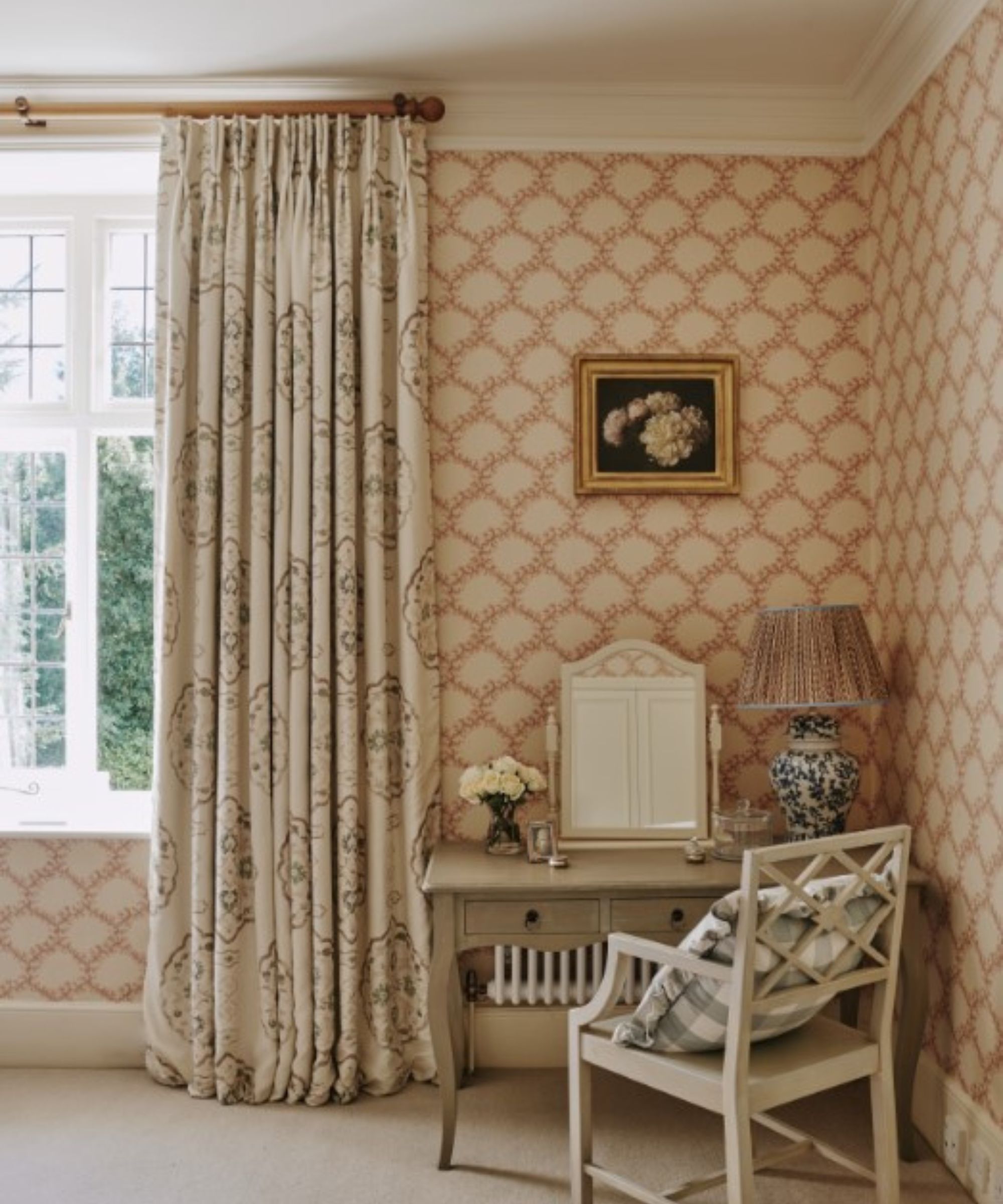 Chambre de printemps avec papier peint imprimé, rideaux à imprimé doux, bureau de vanité en bois avec miroir et chaise en bois avec coussin de vichy