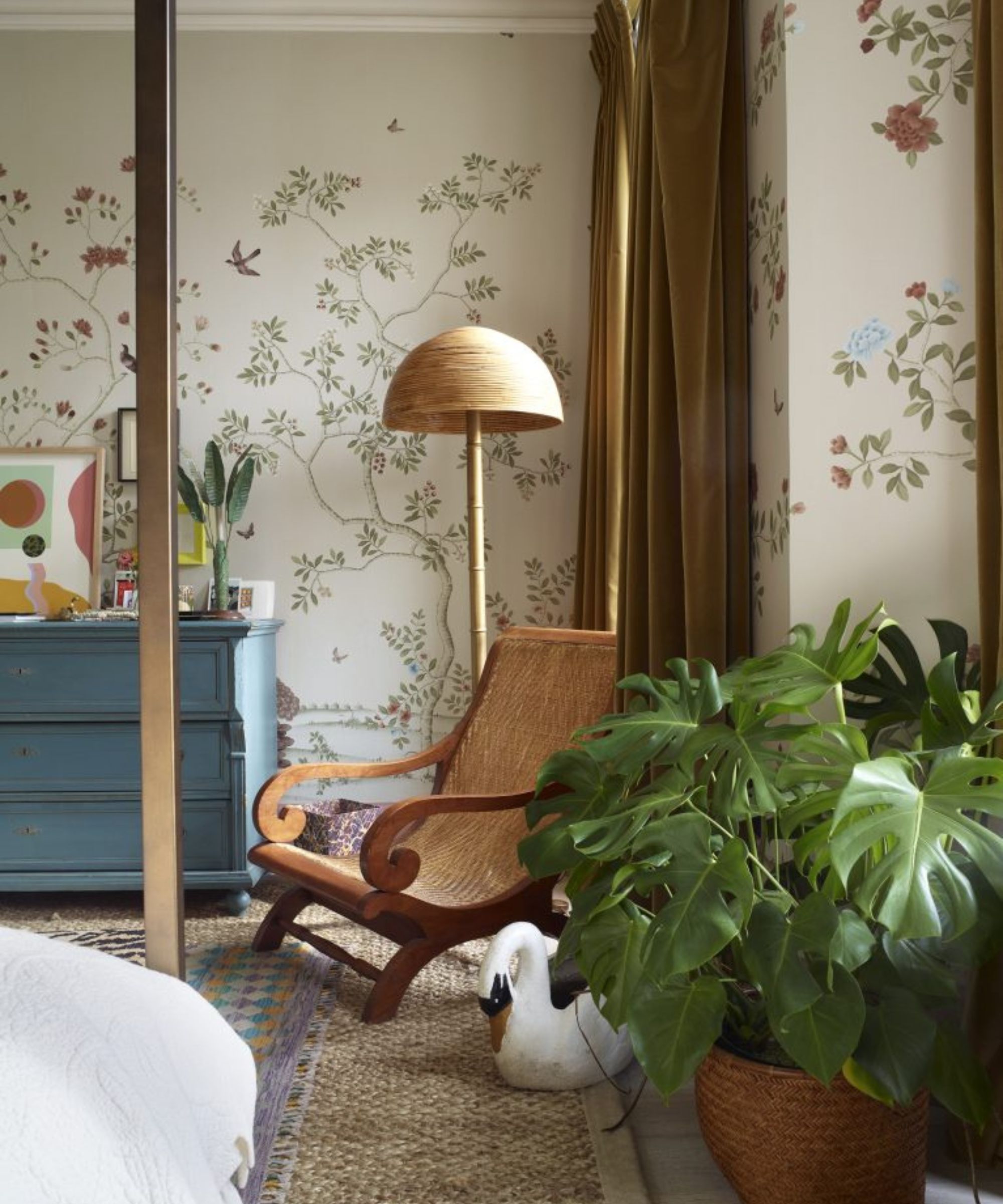 Chambre peint mural floral avec coffre bleu vintage et un petit rotin et chaise en bois