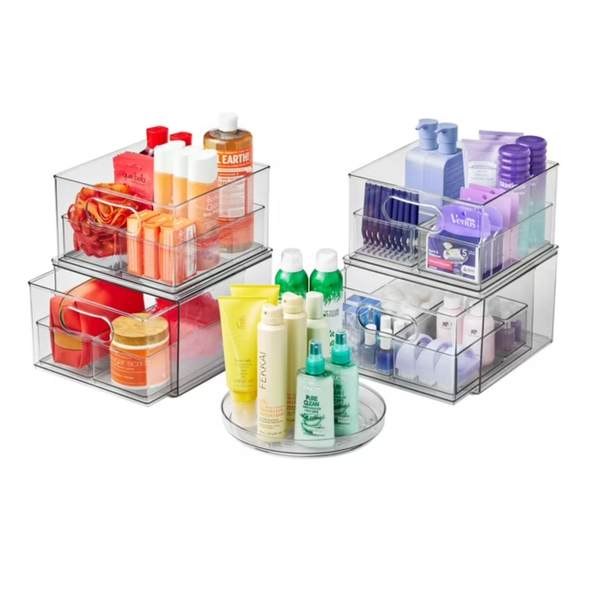 Trois organisateurs de salle de bain en acrylique transparent rempli de bouteilles et bacs orange, violet, jaune et vert