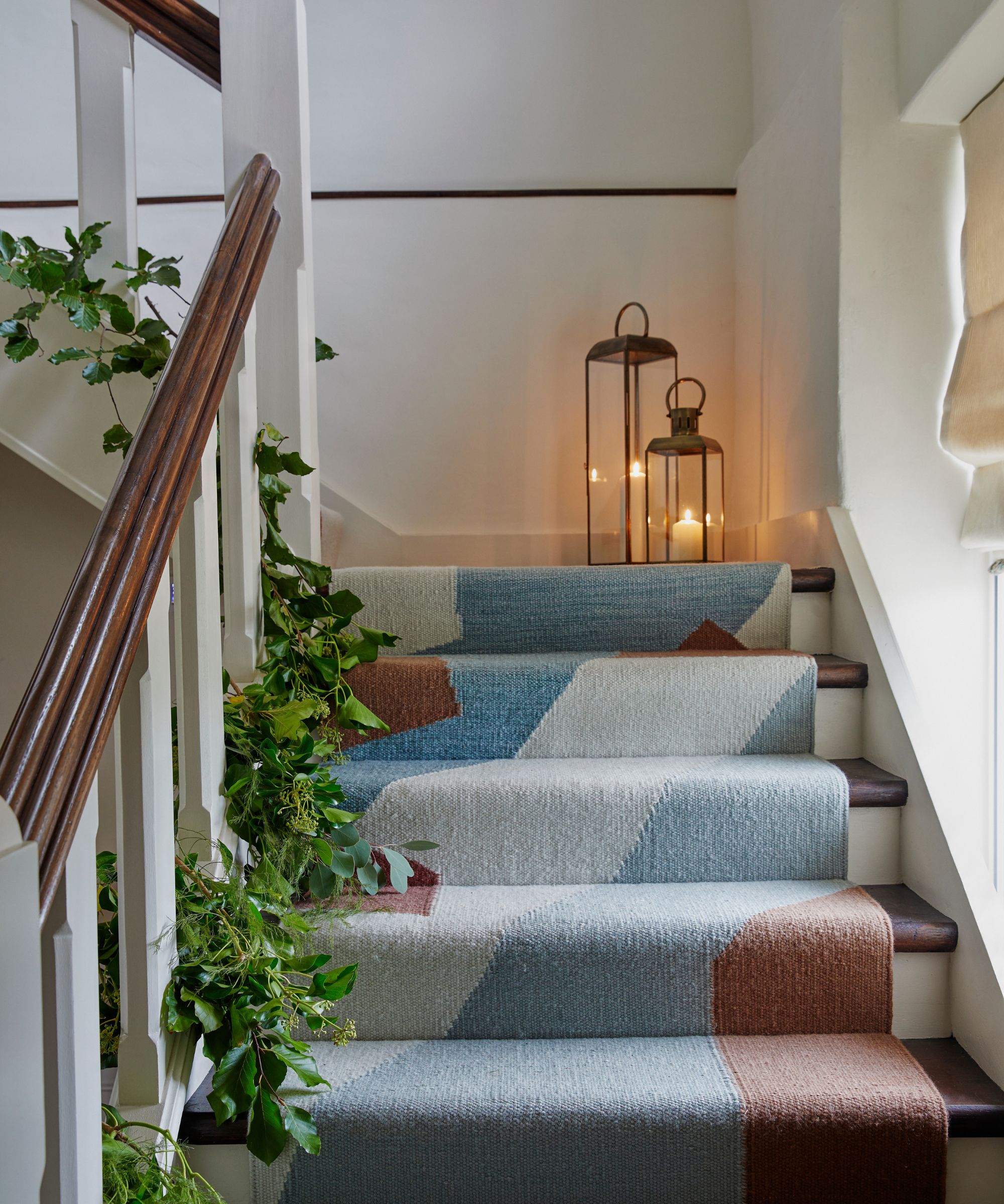 Escalier avec coureur de tapis bleu et guirlande de Noël qui monte sur le bord