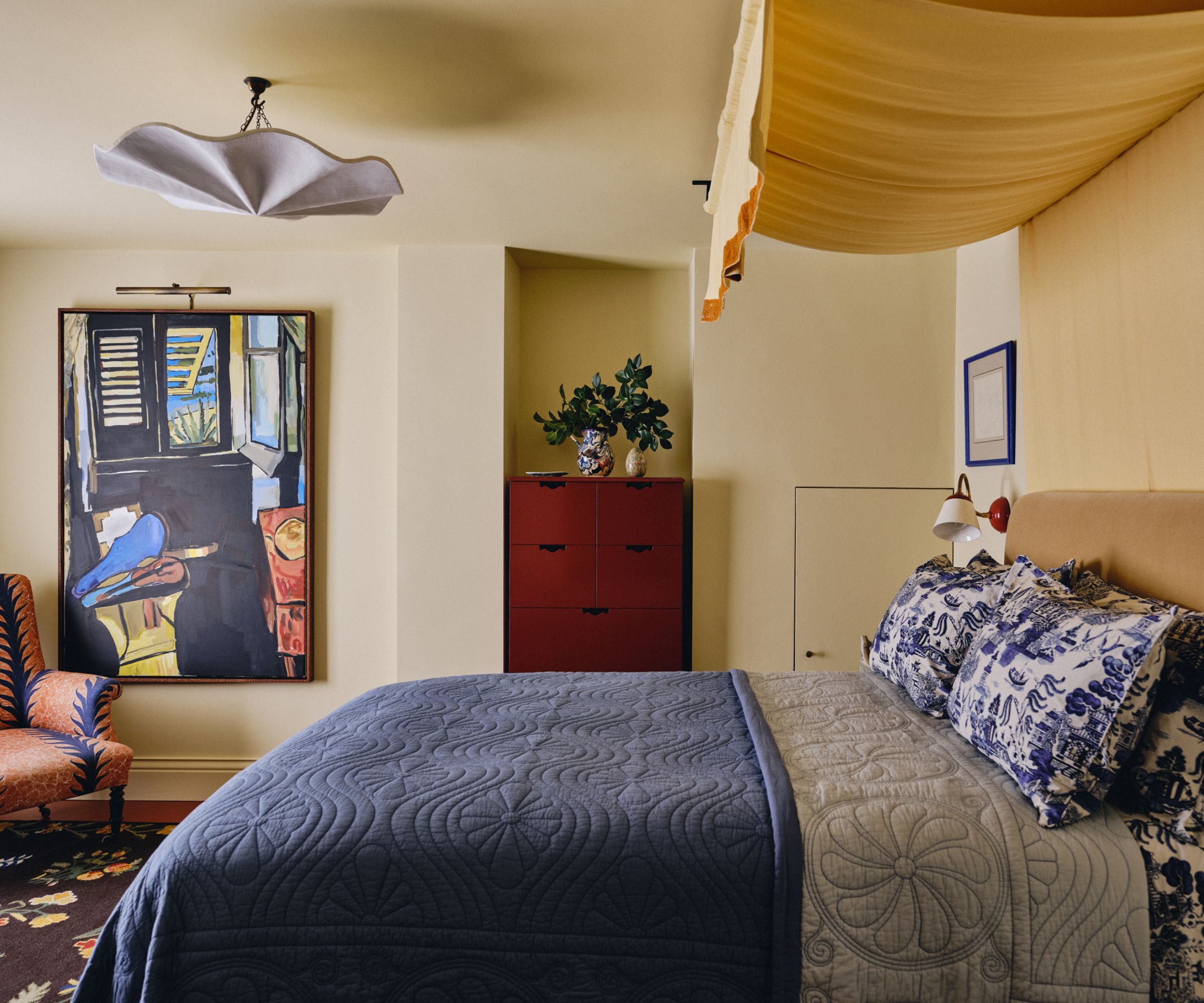 Beurre doux chambre peinte en jaune avec une verrière de lit de tissu jaune et un lit et literie en tissu Chintz bleu