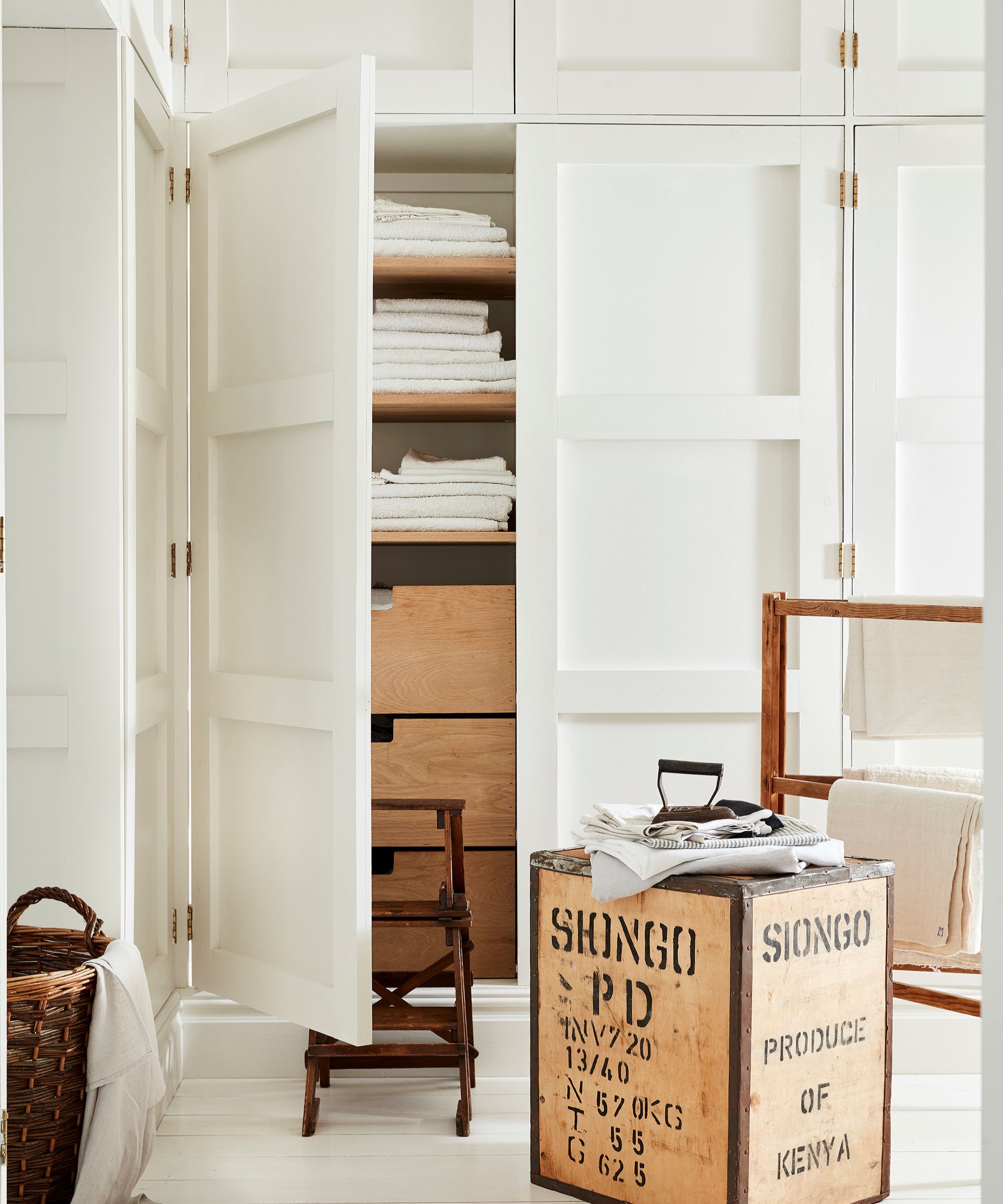Armoires blanches avec une porte ouverte avec des étagères à l'intérieur, unité de rangement en bois à l'avant