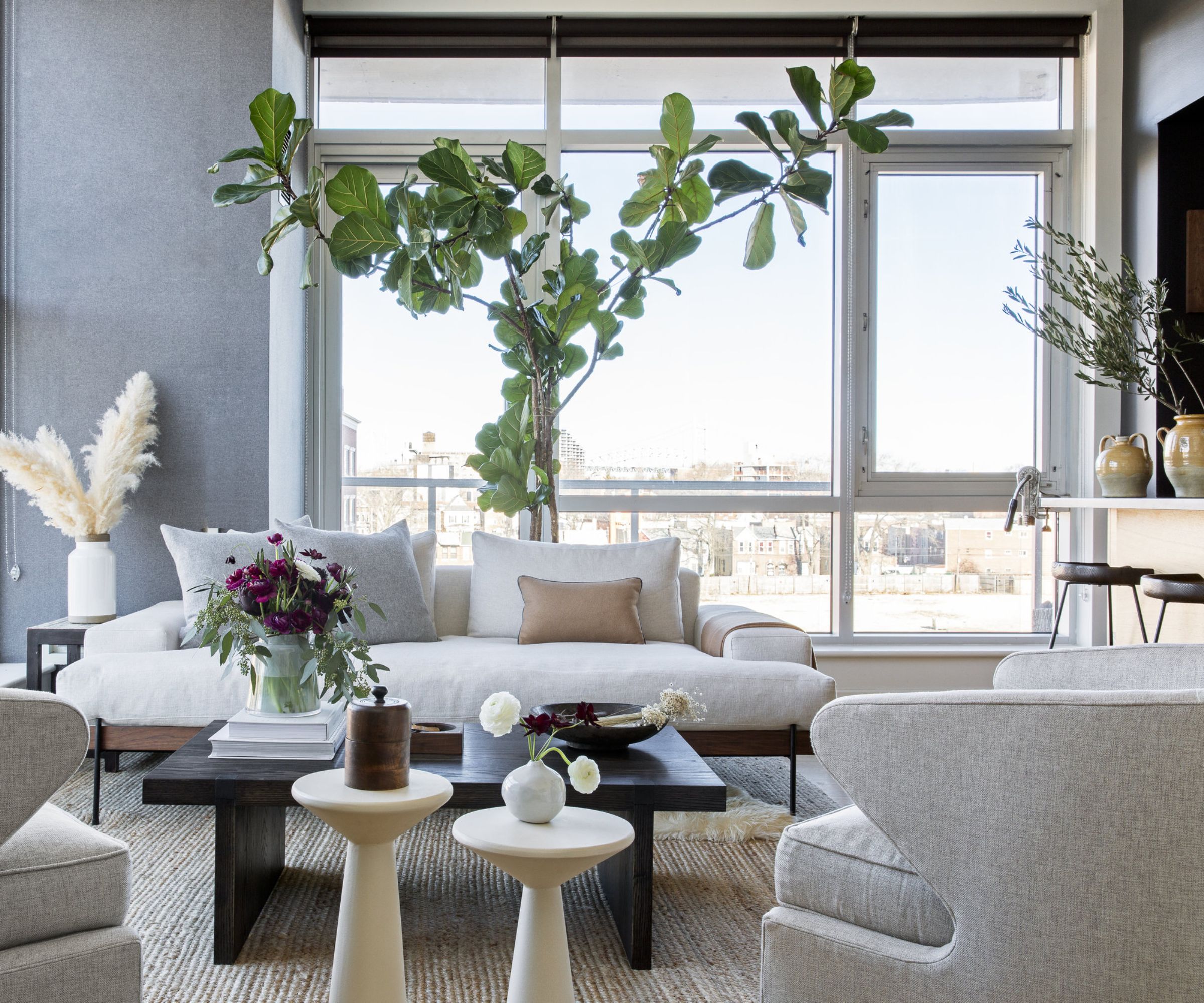 salon d'appartement moderne avec un petit canapé blanc et une collection de meubles contemporains et de vases de plantes et de feuillage