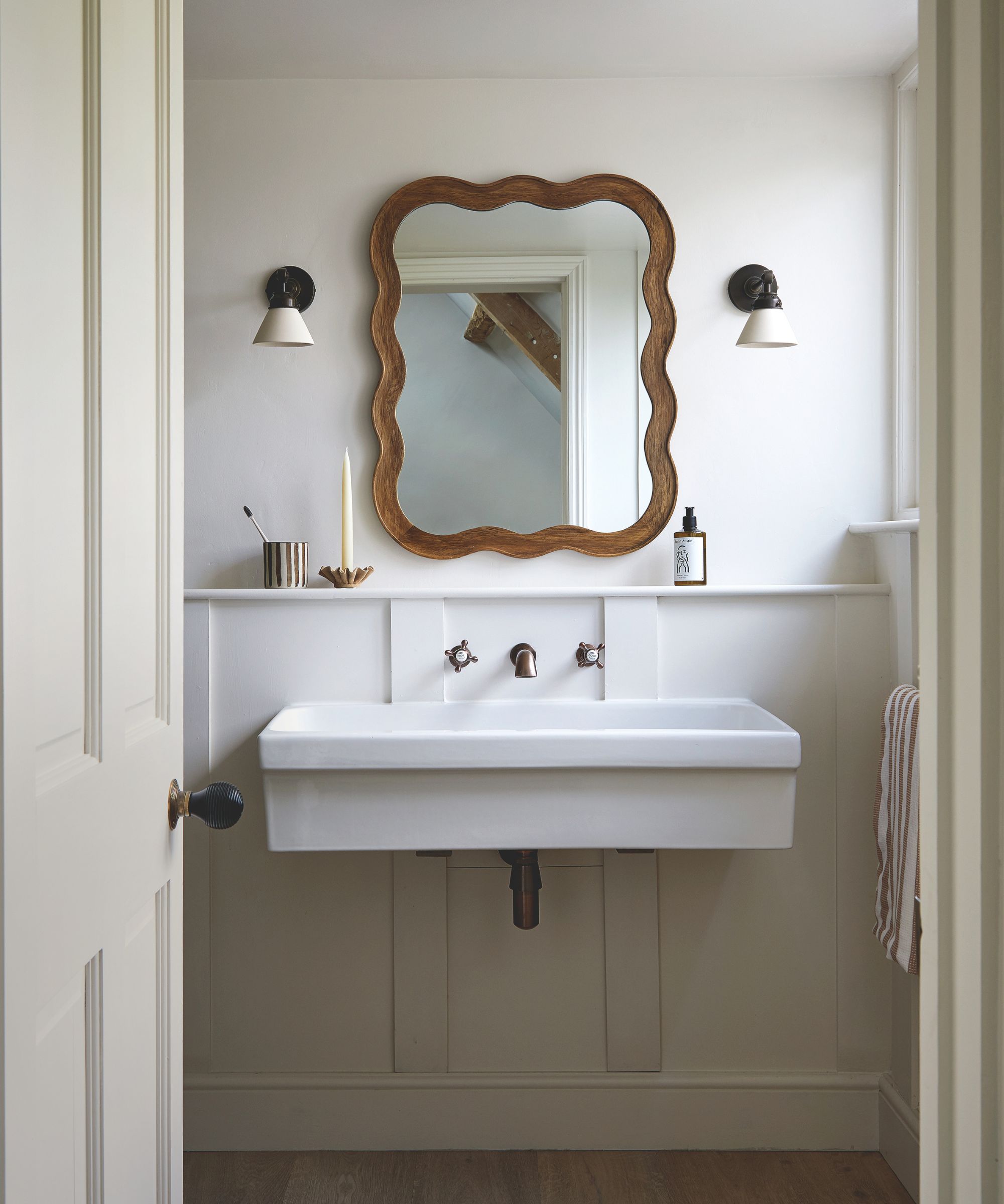 Salle de bain avec un grand lavabo flottant minimaliste et miroir en bois à baignade ondulé