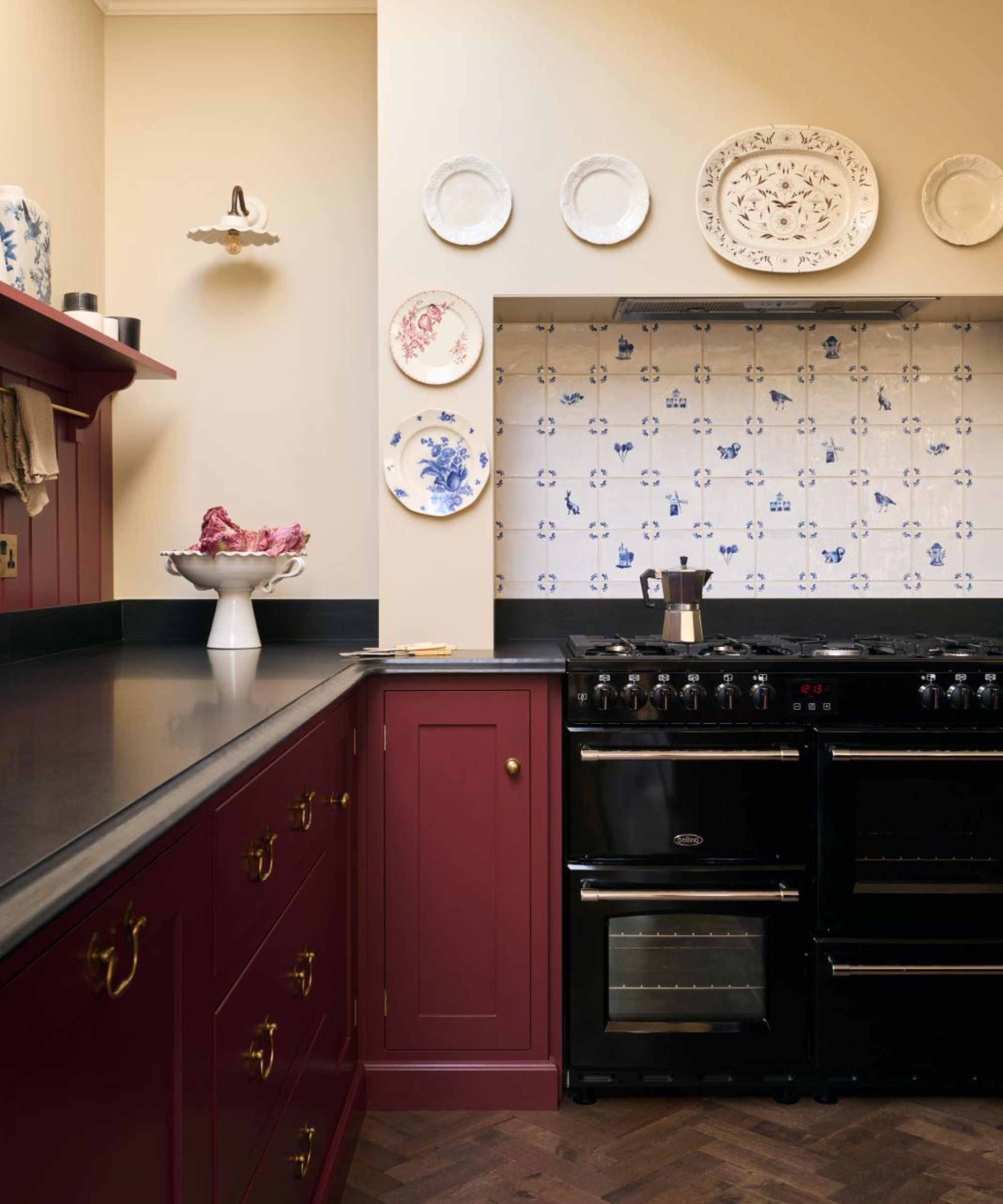 Cuisine shaker de style vintage peinte en rouge bordeaux avec une grande cuisinière et une hotte carrelée en carreaux de Delft vintage