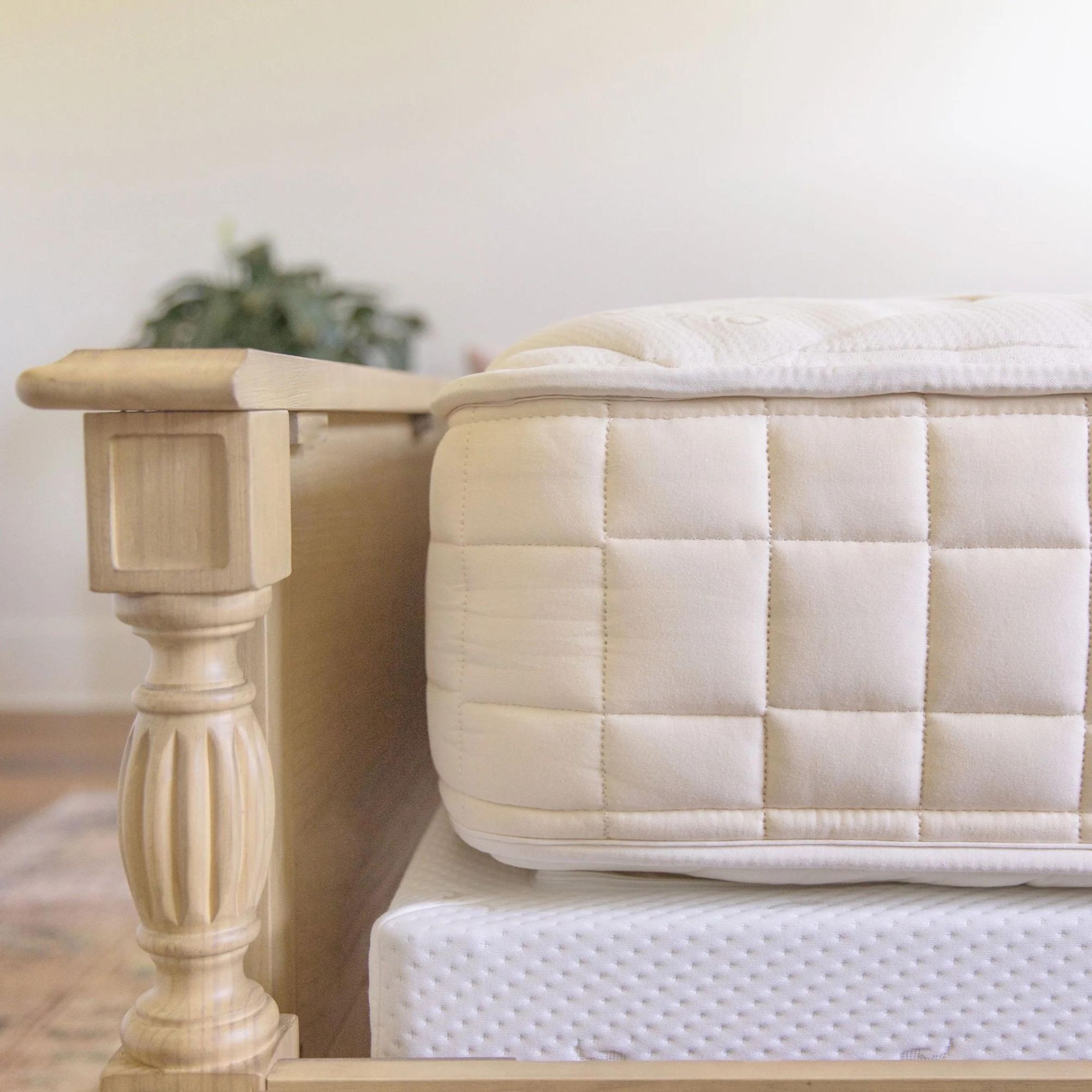 Coin d'un matelas de chœur Naturedpedic sur un lit.
