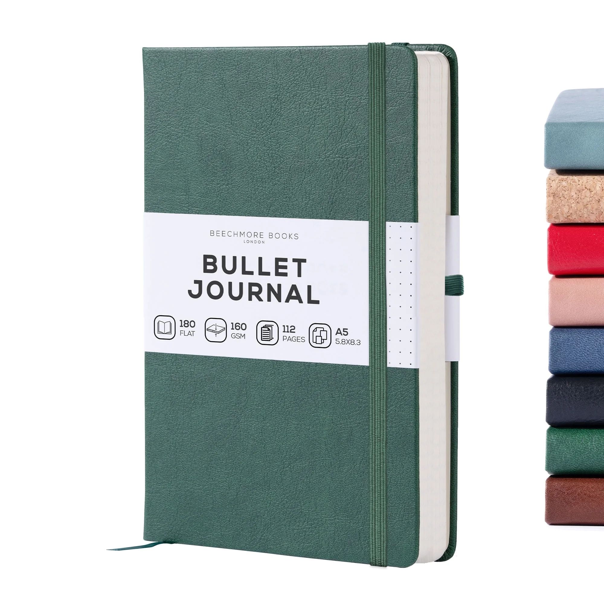 Un journal de balle vert avec une étiquette blanche avec du texte noir et une fermeture élastique assortie à côté d'une pile de huit autres journaux de différentes couleurs et textures