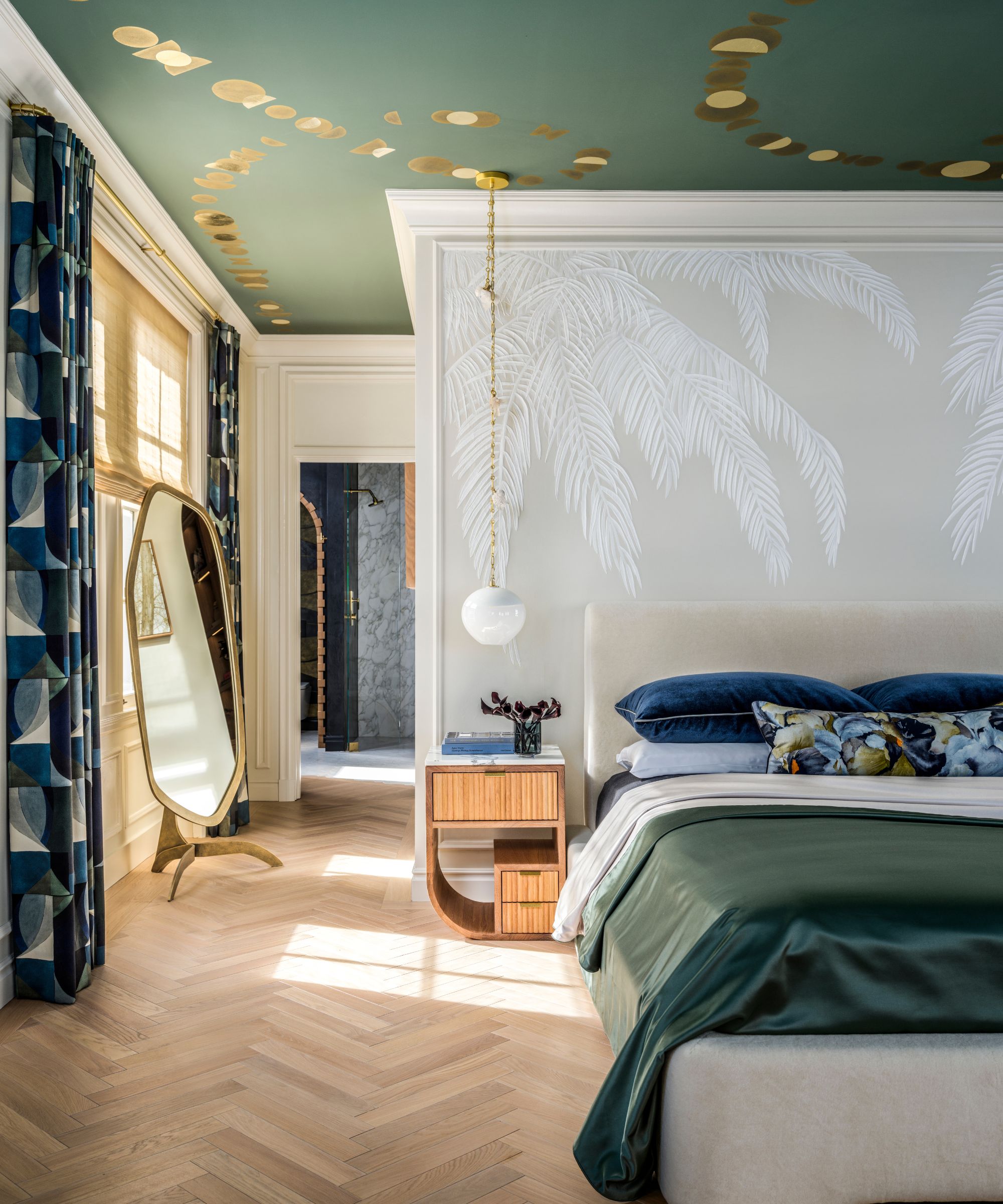 Grande chambre avec murmure mural blanc, literie verte, sols en parquet, plafond à motifs verts