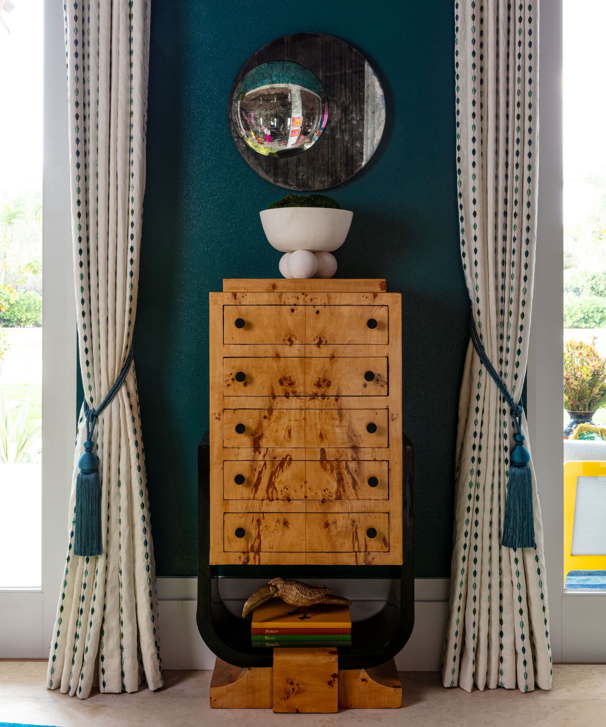 mur sarcelle foncé avec armoire en bois, draps à motifs crème et bleu