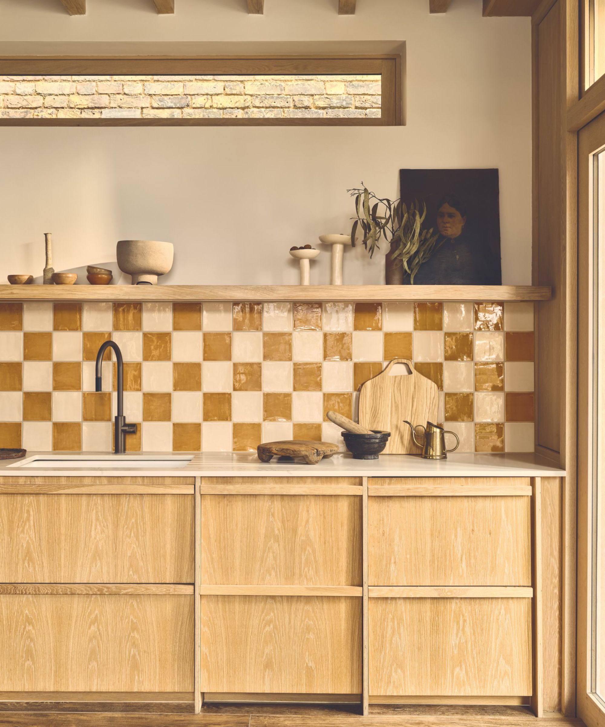 Une cuisine en bois avec un dosseret de carreaux à damier à tons terrestres
