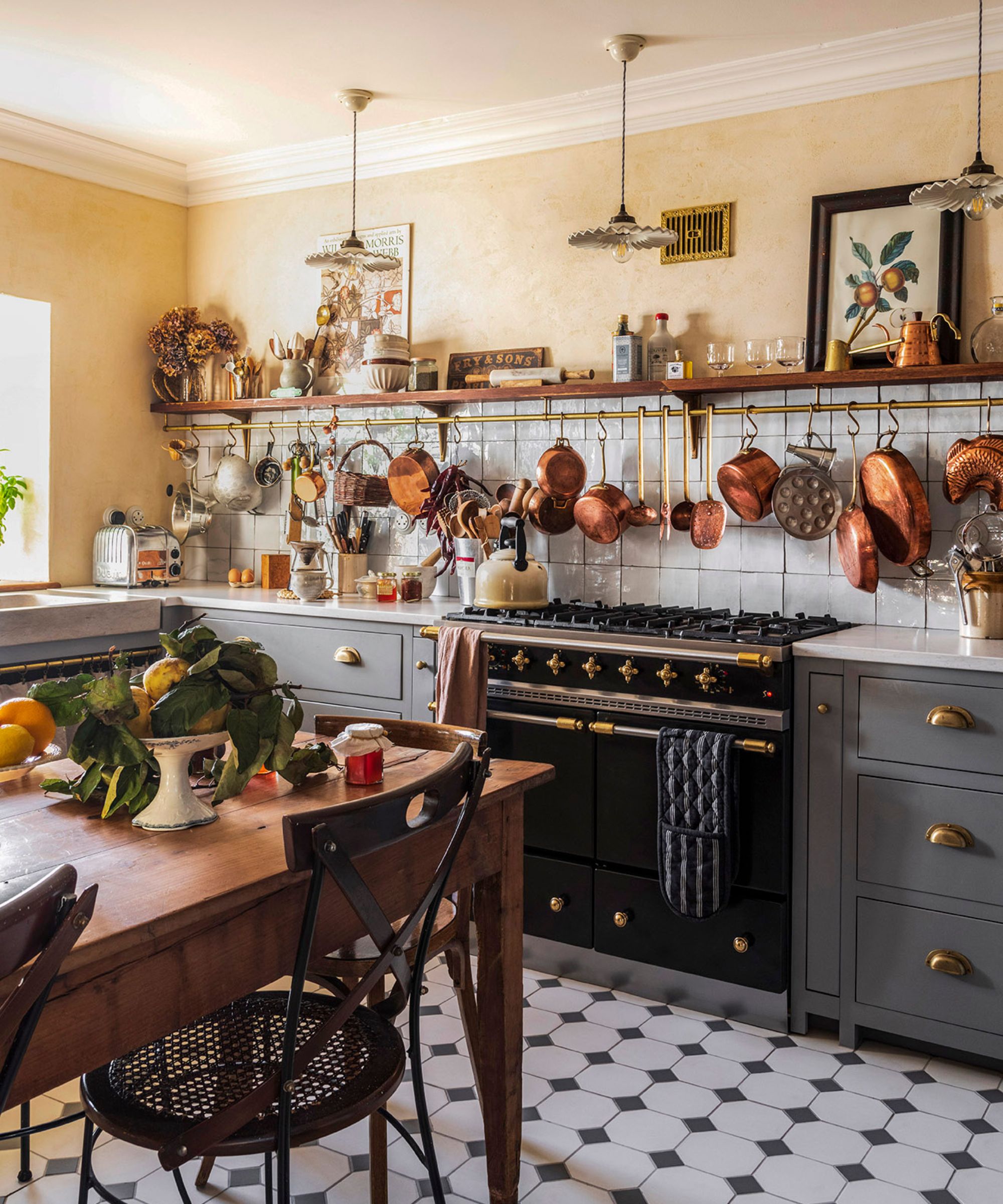 Une cuisinière traditionnelle noire et laiton dans une cuisine de style paysan