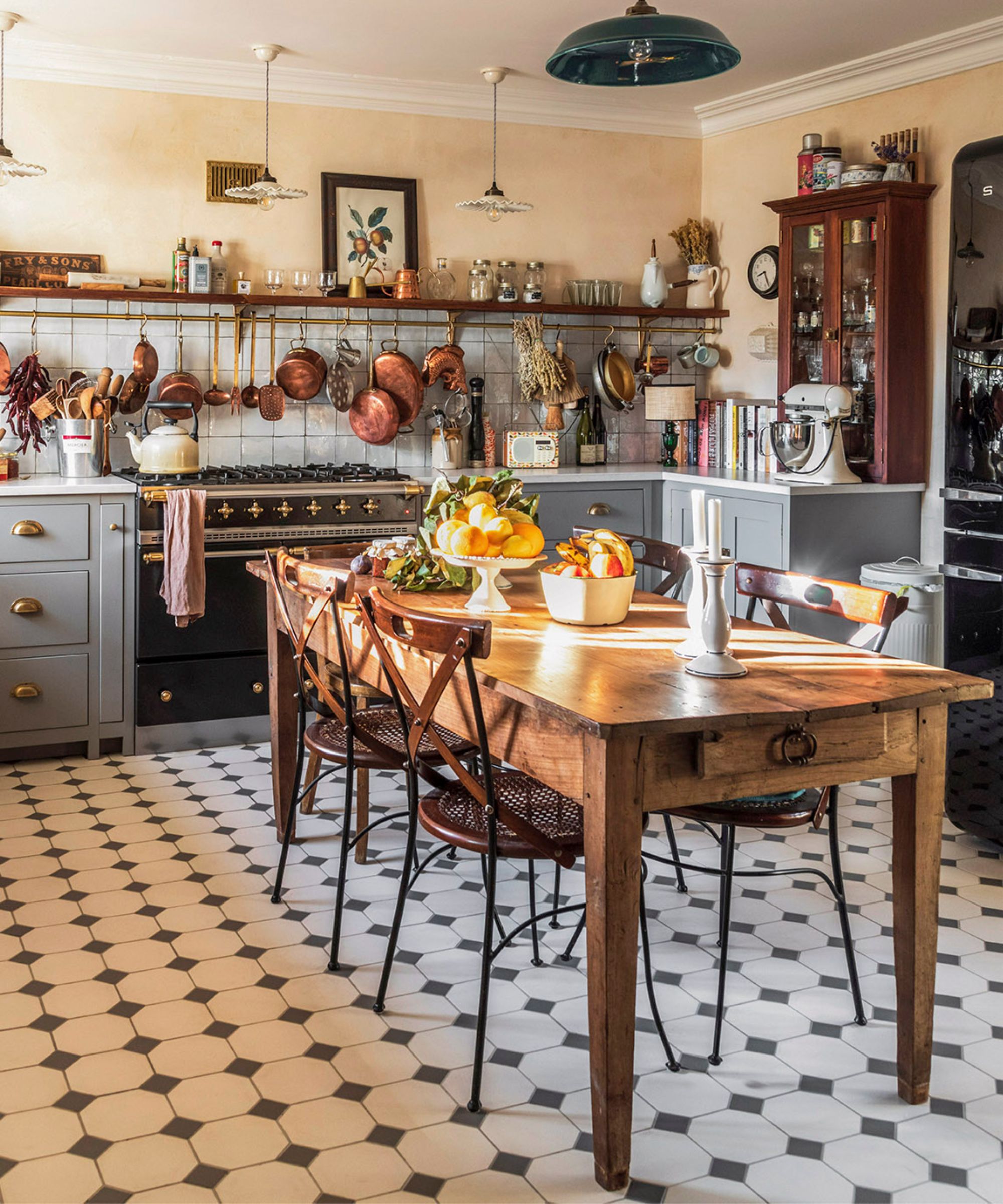 Une cuisine de style country française avec une table de cuisine en bois traditionnelle au centre