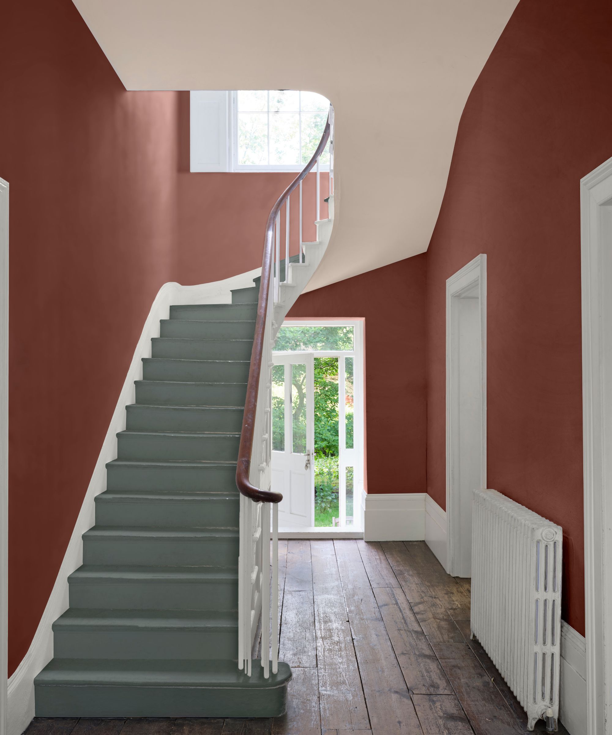 Couloir rouge avec plancher en bois, escalier bleu et grande porte