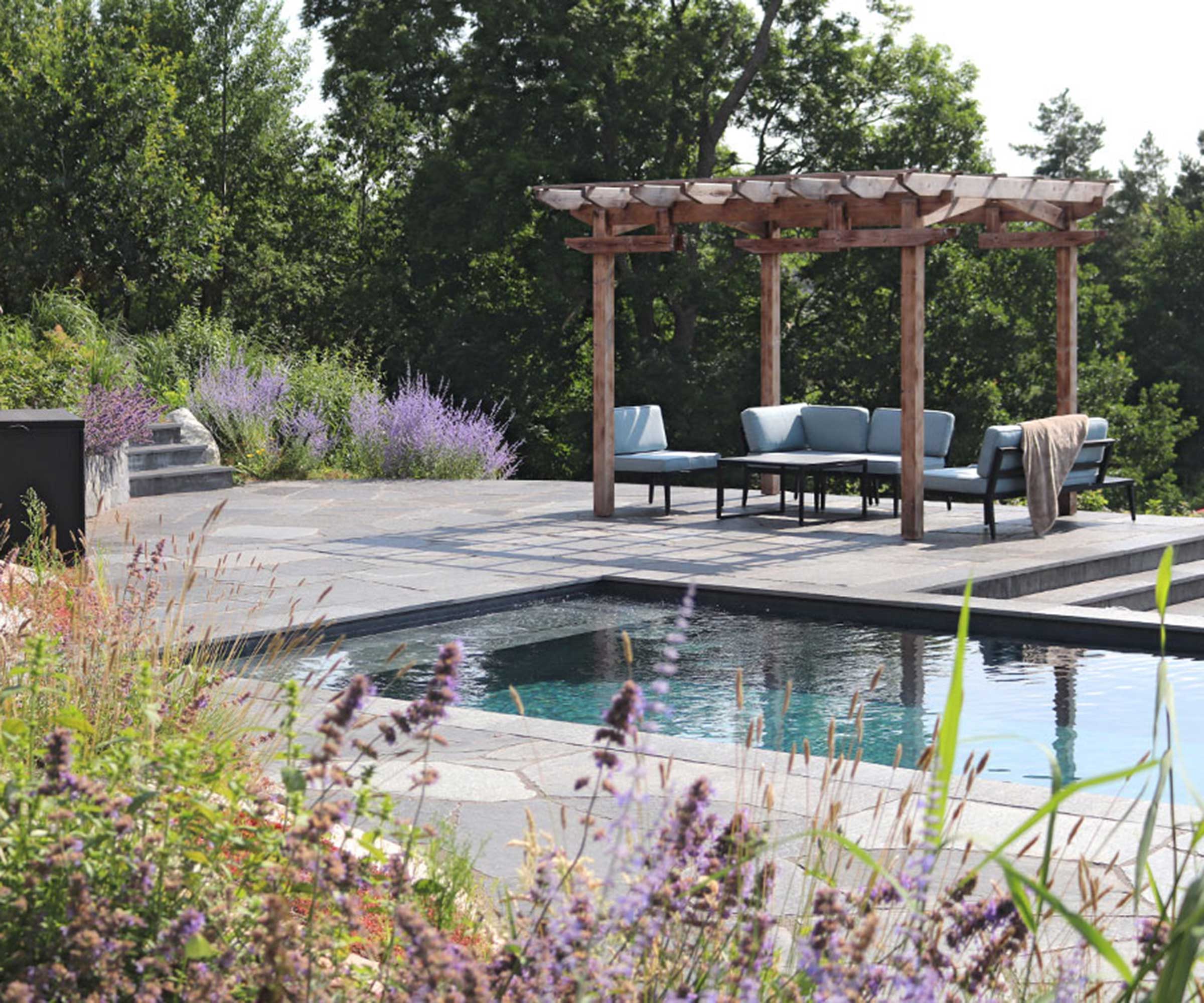 piscine et pergola sur des sièges dans le jardin conçu par Annika Zetterman