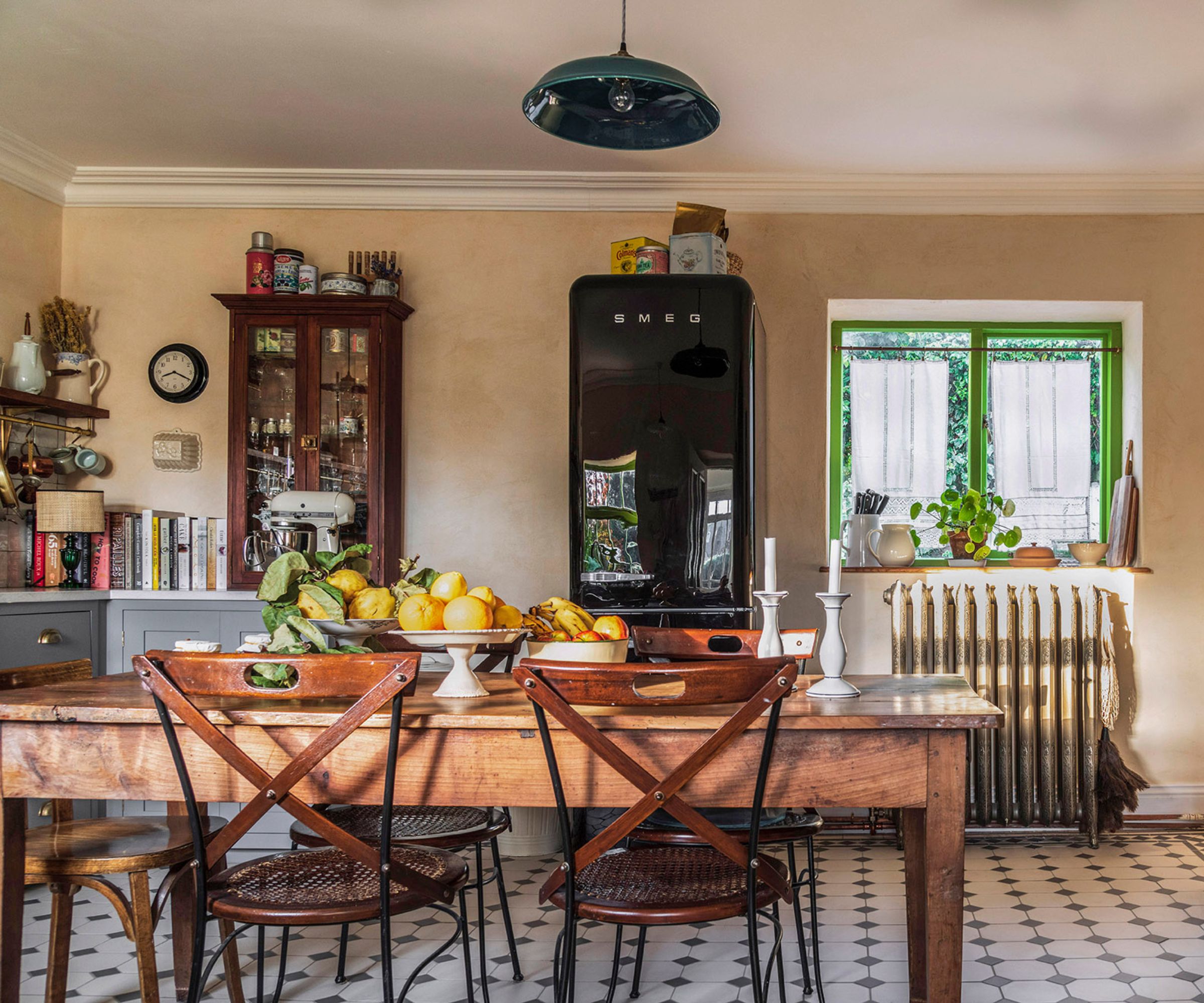 Une cuisine de style country française avec un réfrigérateur smeg et une table de cuisine en bois