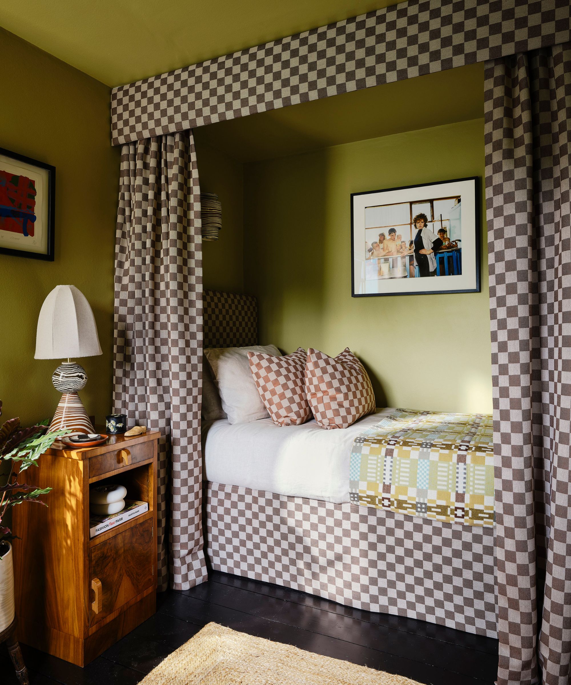 chambre verte avec un coin de lit de canopée intégré avec des rideaux en damier, une jupe de lit et des oreillers à lancer assorti décorés de meubles vintage et de décoration