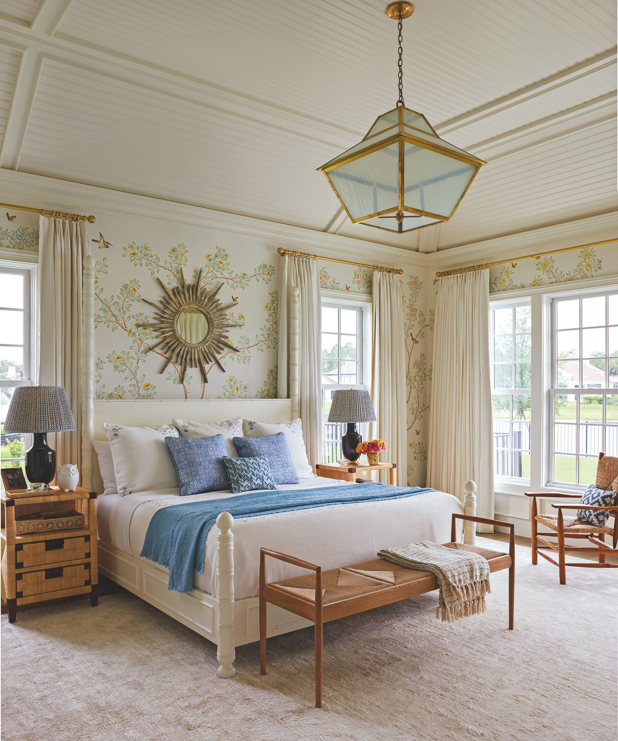 Chambre avec papier peint à motifs et lit rembourré à la crème et pendentif orné en or