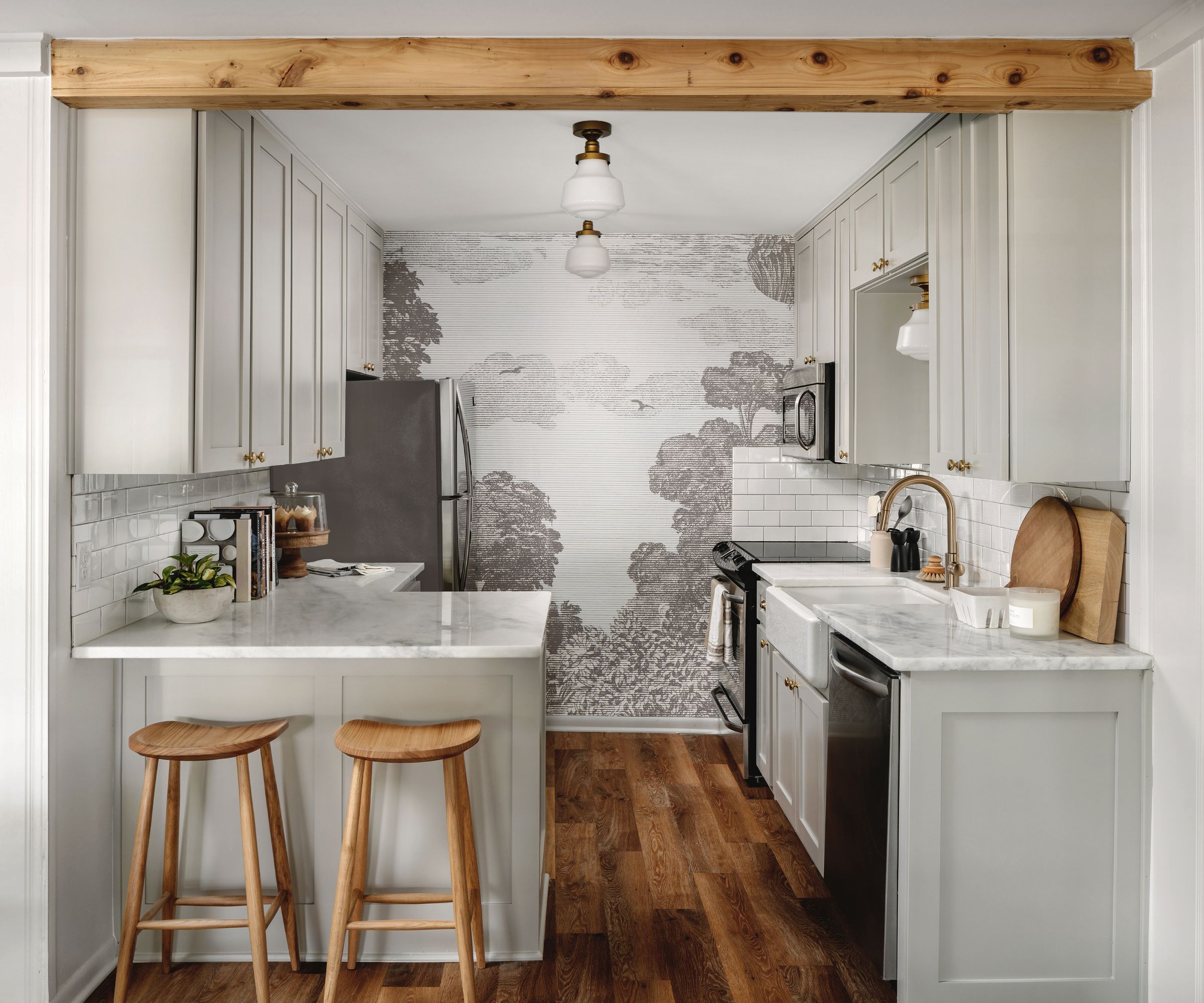 Une petite cuisine de cuisine en gris sorcière gris, de la quincaillerie en laiton, une murale murale gris et blanche et un décor en bois