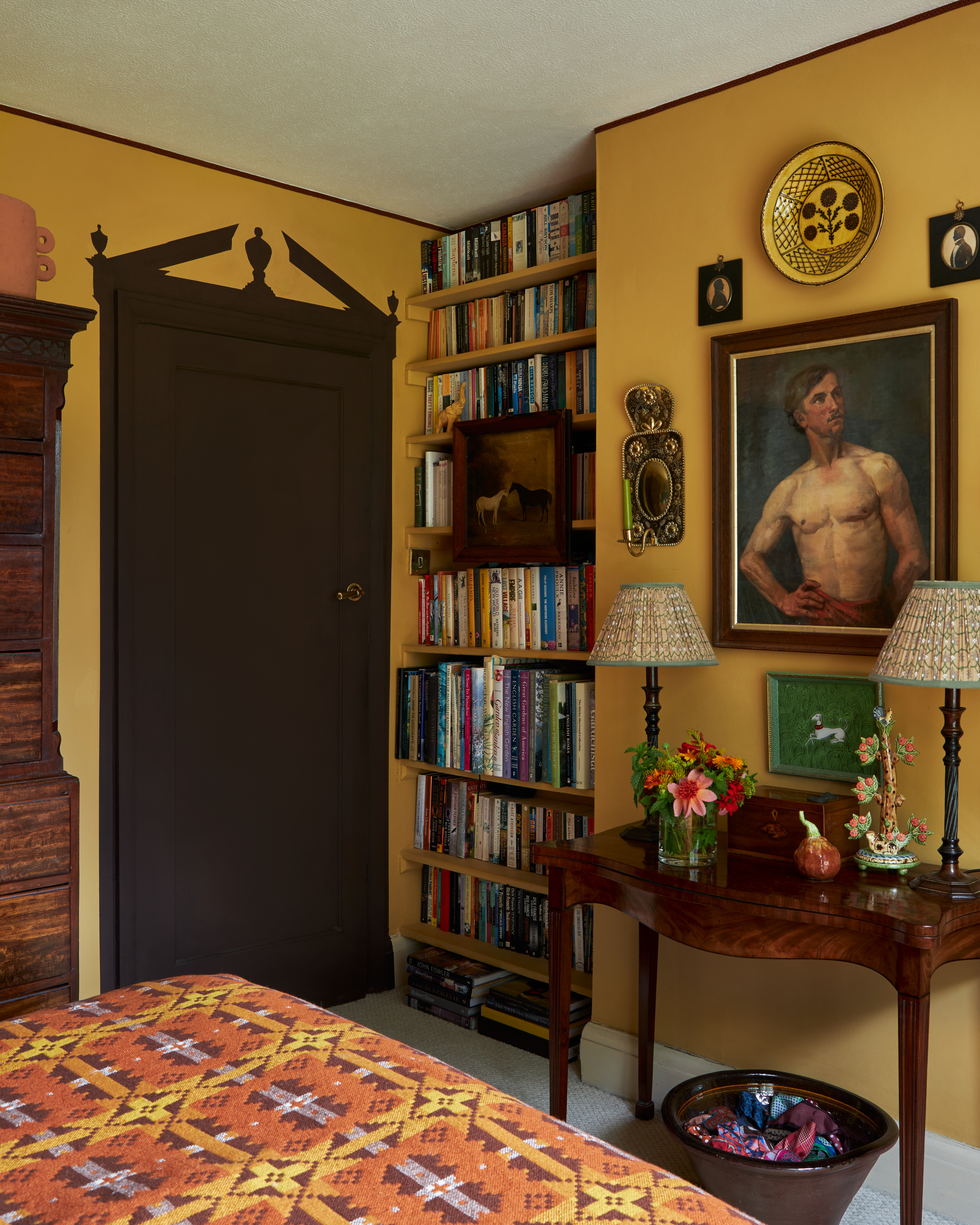 Une chambre jaune avec une porte brune, autour de la porte, une garniture décorative a été peinte