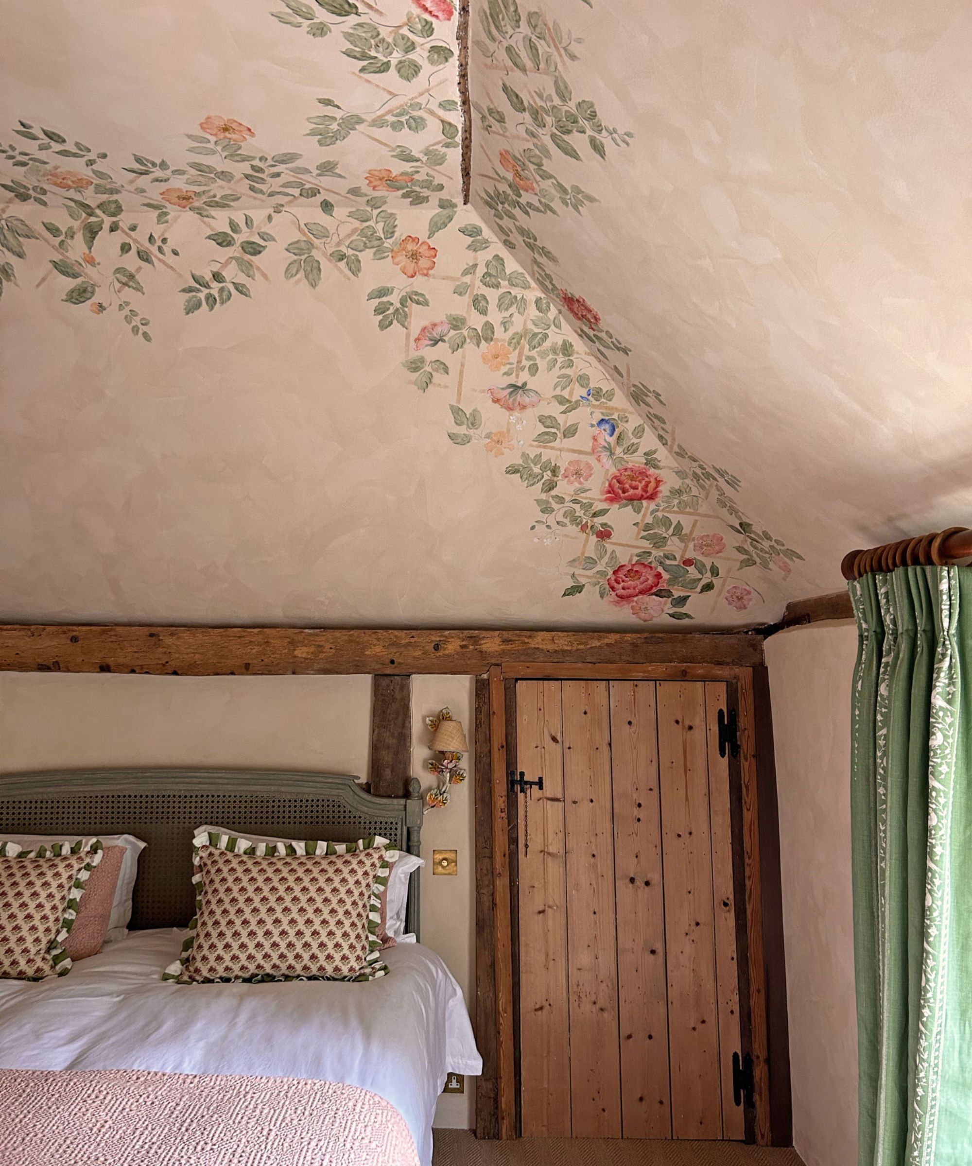Une chambre à coucher avec un effet parchemin et des détails architecturaux encadrés avec des fleurs et un feuillage pour donner la sensation d'être dans une salle de jardin.