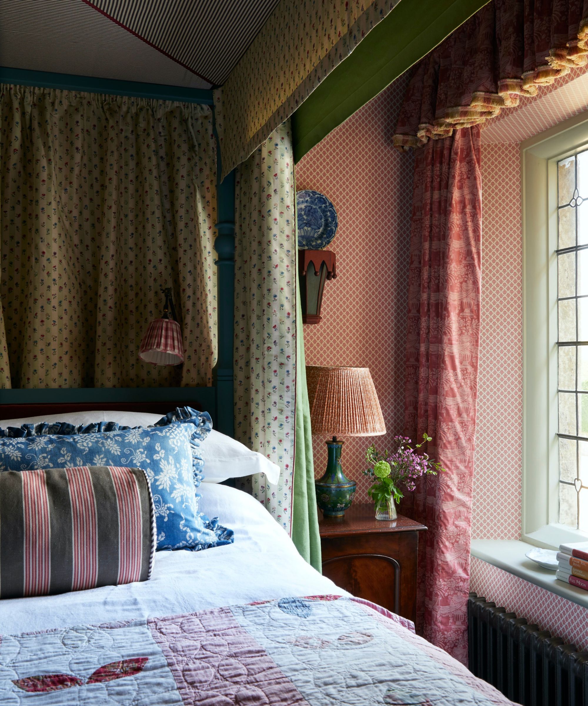 Chambre vintage avec canopée et courtepointe sur lit et rideaux floraux
