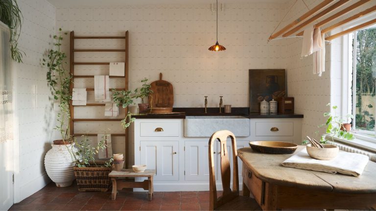 Soudain, chaque pièce élégante a ce seul meuble simple en commun – pourquoi les designers aiment la polyvalence des humbles tabourets Farmhouse kitchen with wood round table, white cabinets, low pendant light, wood stall and plants
