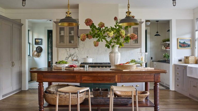 Les cuisines midimalistes sont le moyen tendance pour créer un espace de caractère sans encombrement – et ces 8 espaces prouvent à quel point ce meilleur du style des deux mondes peut être chic A midimalist kitchen with warm white cabinets, a wooden freestanding island, and collected decor