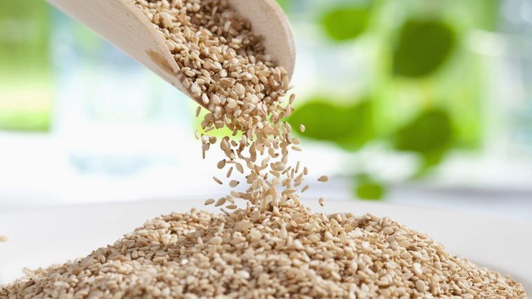 Comment cultiver des plantes de sésame et récolter des graines riches en nutriments pour les grignoter, la cuisson ou la cuisson Sesame seeds pouring out of a wooden scoop into a pile