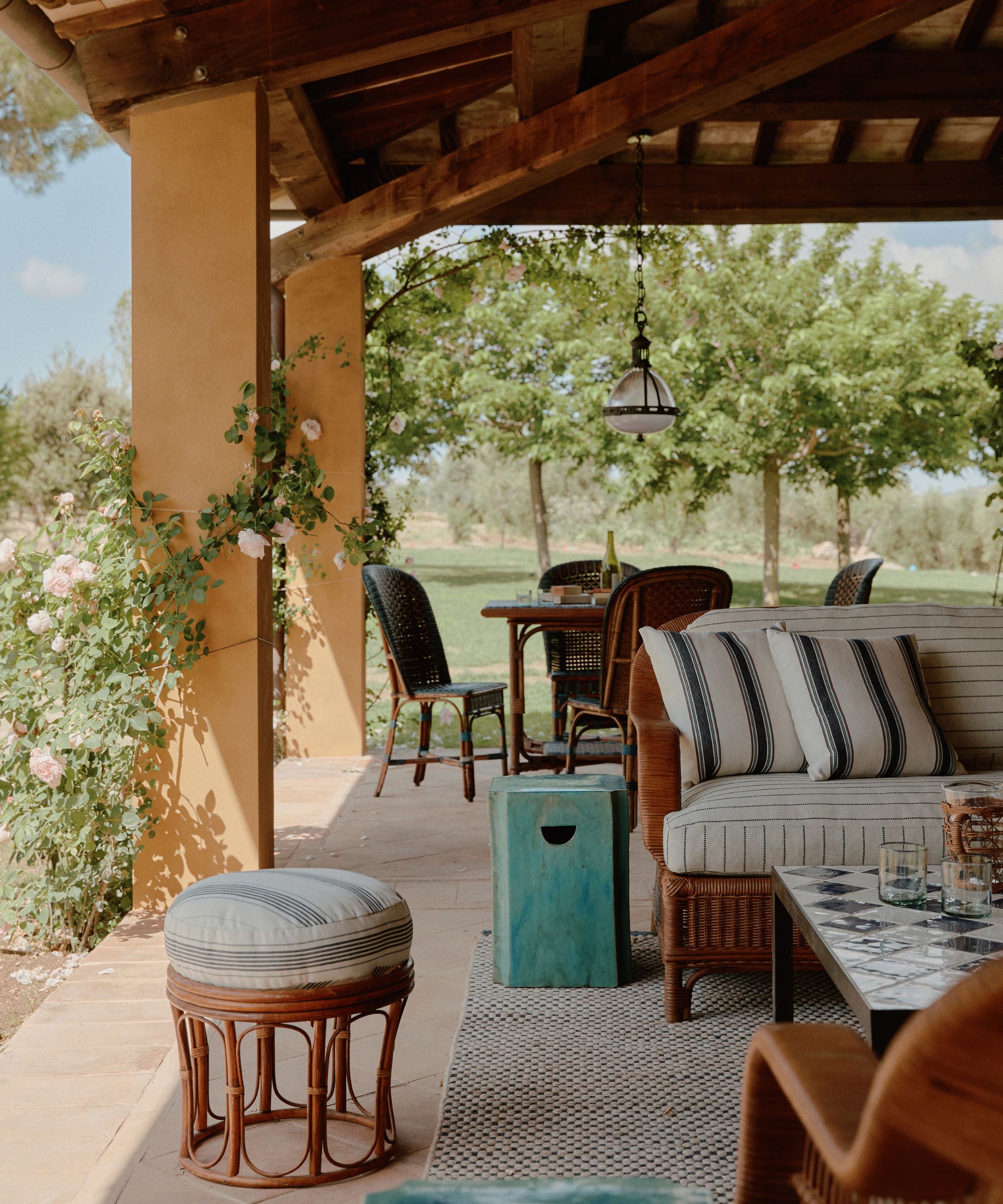 Salon extérieur avec meubles en rotin et coussins rayés