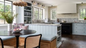Est-ce la caractéristique de caractère que votre cuisine pourrait manquer? 10 façons dont les concepteurs apportent des panneaux dans un espace travailleur A kitchen with a peninsula island, a dining nook with banquette seating, and blue cabinets