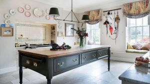 Entrez dans cette cuisine majestueuse britannique imprégnée de charme de campagne – une cuisine construite pour l’instant, avec l’âme d’une autre époque A green freestanding kitchen island takes pride of place in a country kitchen