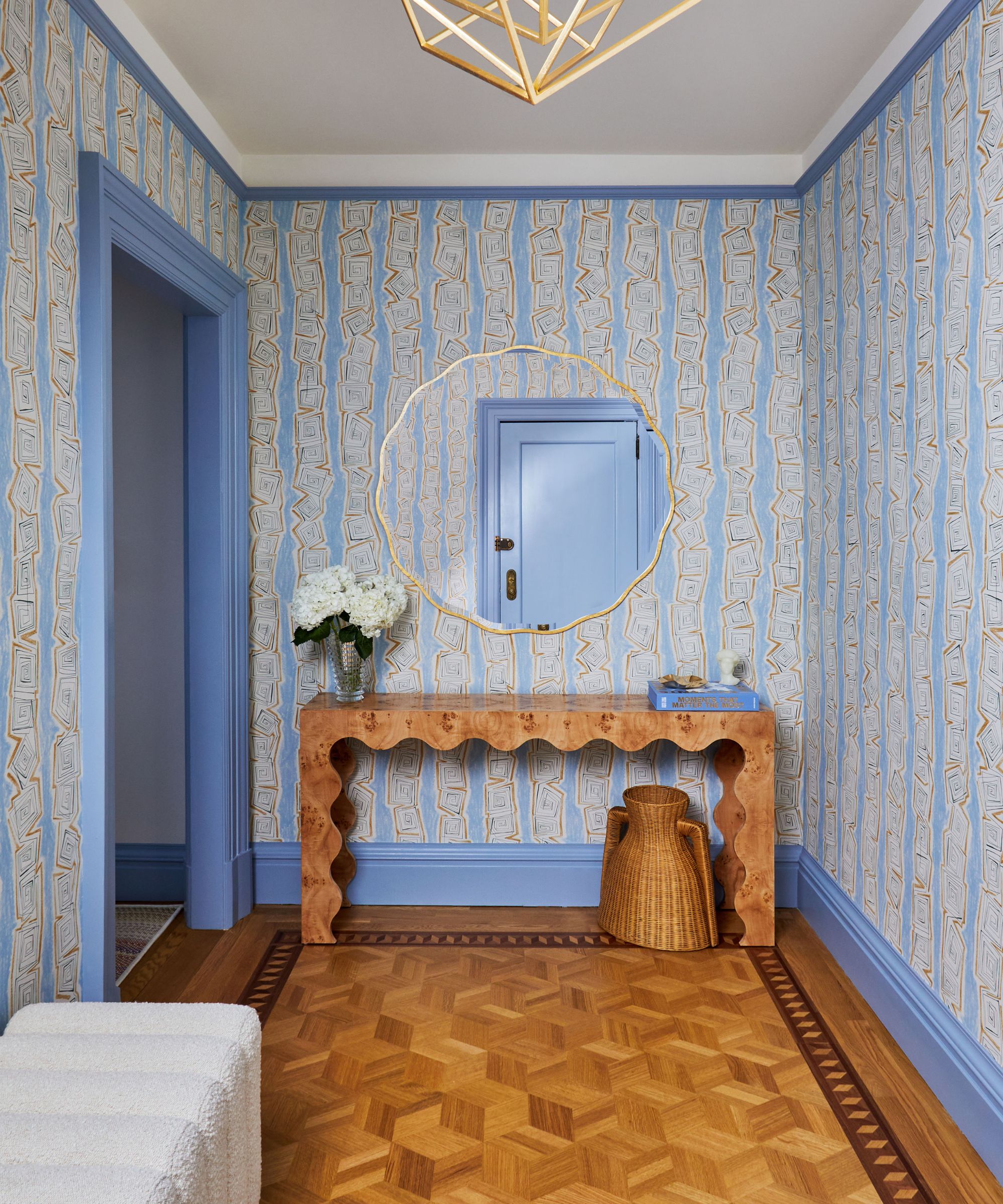 Entrée avec papier peint bleu et boiseries et parquet