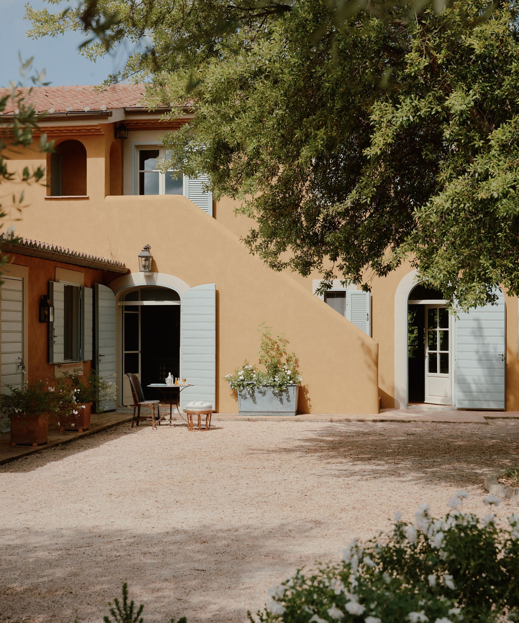Extérieur d'une maison orange pâle avec des volets bleu pâle
