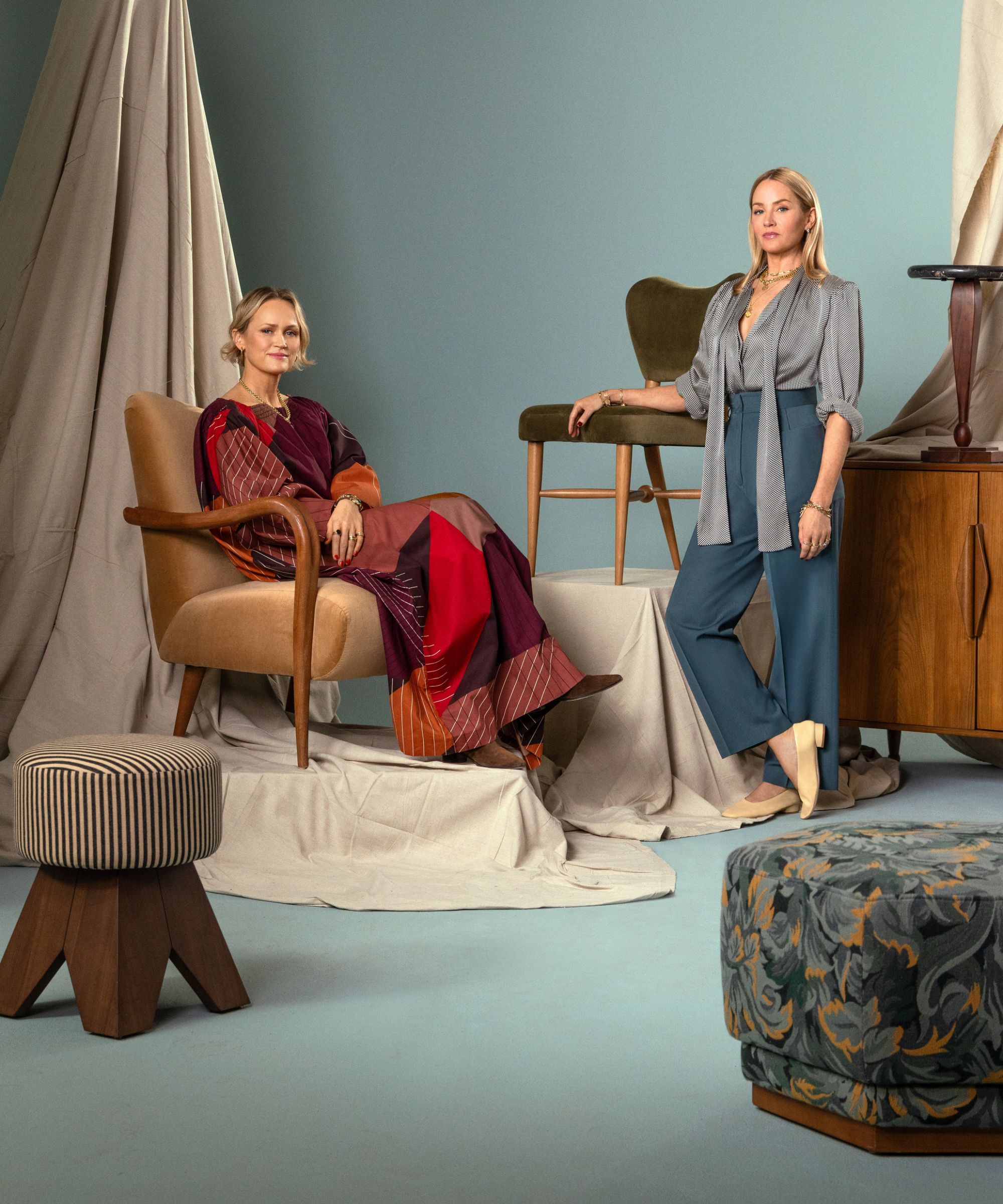 Designers Piece and Ward Portrait Image pour leur collaboration West Elm avec une toile de fond bleue avec quelques meubles coiffés autour d'eux