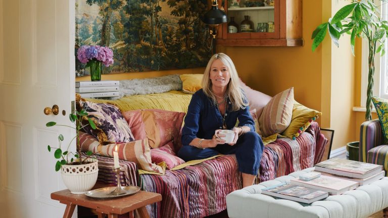 A woman on a colourful sofa holding a mug
