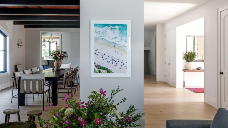 Les experts révèlent pourquoi la lutte contre les « tâches non préférées » est la clé pour éliminer les bloqueurs de corvées ennuyeux à la maison Open plan living space showing dining room on left, entryway on right with florals and artwork