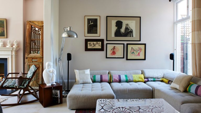 « Ne dépuisez pas votre maison de son âme juste pour plaire à un futur acheteur imaginaire » – et 5 autres décisions de conception experts immobiliers avertissent d’éviter si vous voulez vendre votre maison au cours des 5 prochaines années Living room with sectional sofa, drawings on walls, silver floor lamp, antique furniture and coffee table