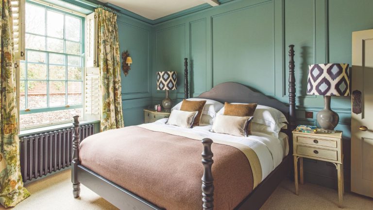 Quiconque dort avec ses fenêtres ouverts la nuit est invité à utiliser cet appareil de 13 $ pour rester cool sans inviter une «armée de ravageurs» à l’intérieur Green paneled bedroom with brown wooden ornate bed with half-height posts, and a large Crittal window in sage. The yellow patterned curtains are floor-to-ceiling height.