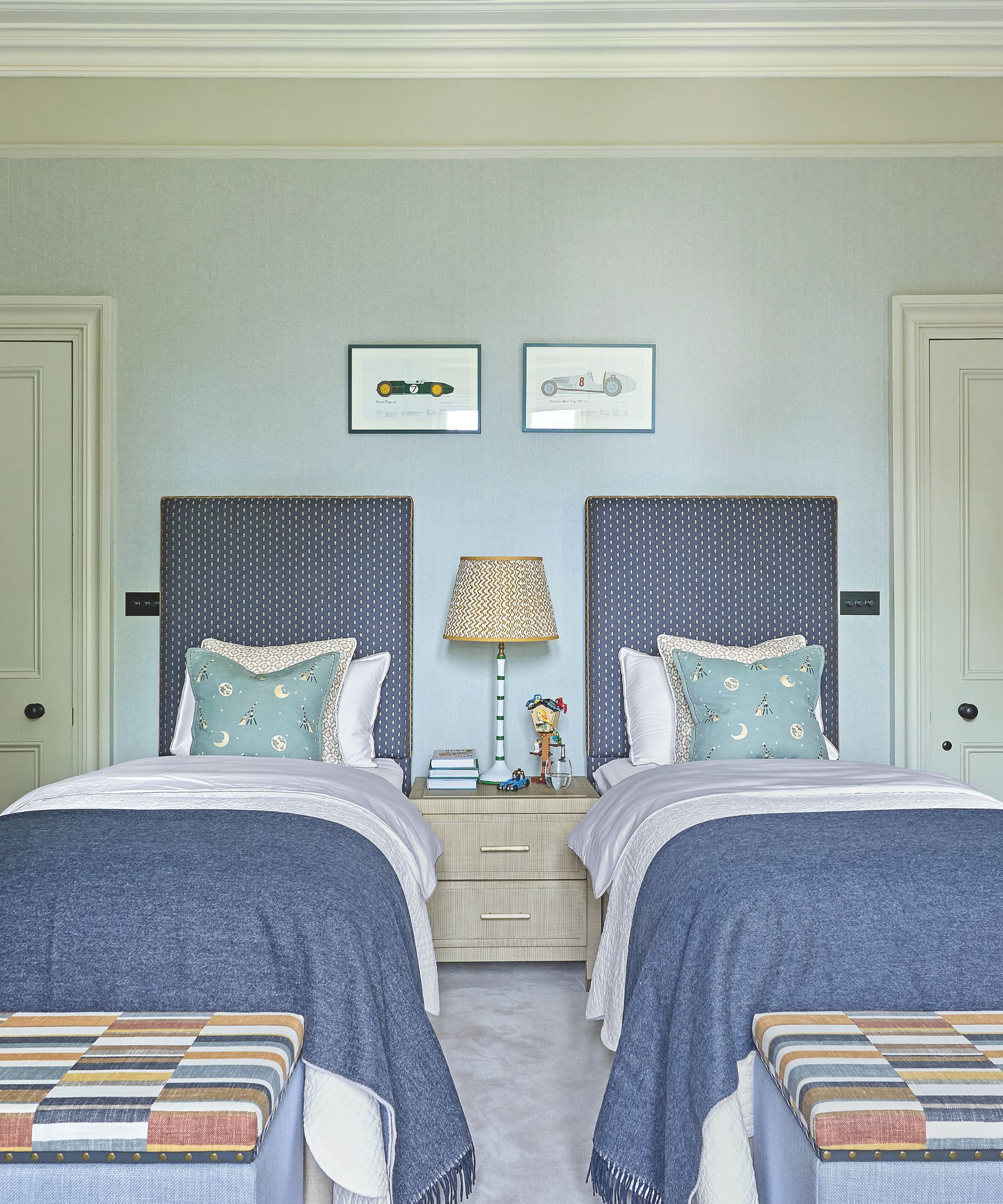 Chambre jumeau bleu pâle avec de grandes têtes de lit bleu et des couvertures bleues à la fin de chaque lit