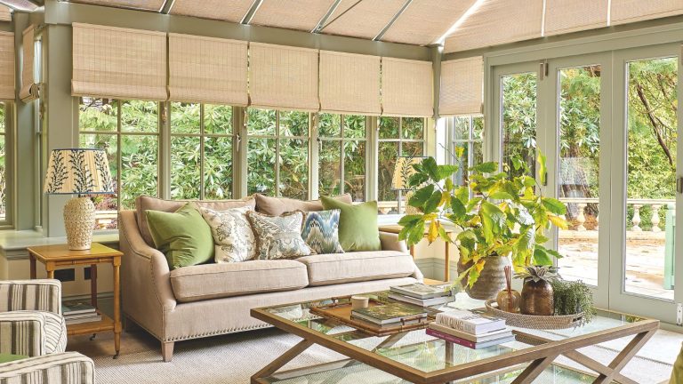 Explorez un imposant manoir dans les Highlands écossais qui a été ramené à la vie avec la couleur, le caractère et une touche contemporaine Sunroom with light green walls, rattan shades and pale beige sofa